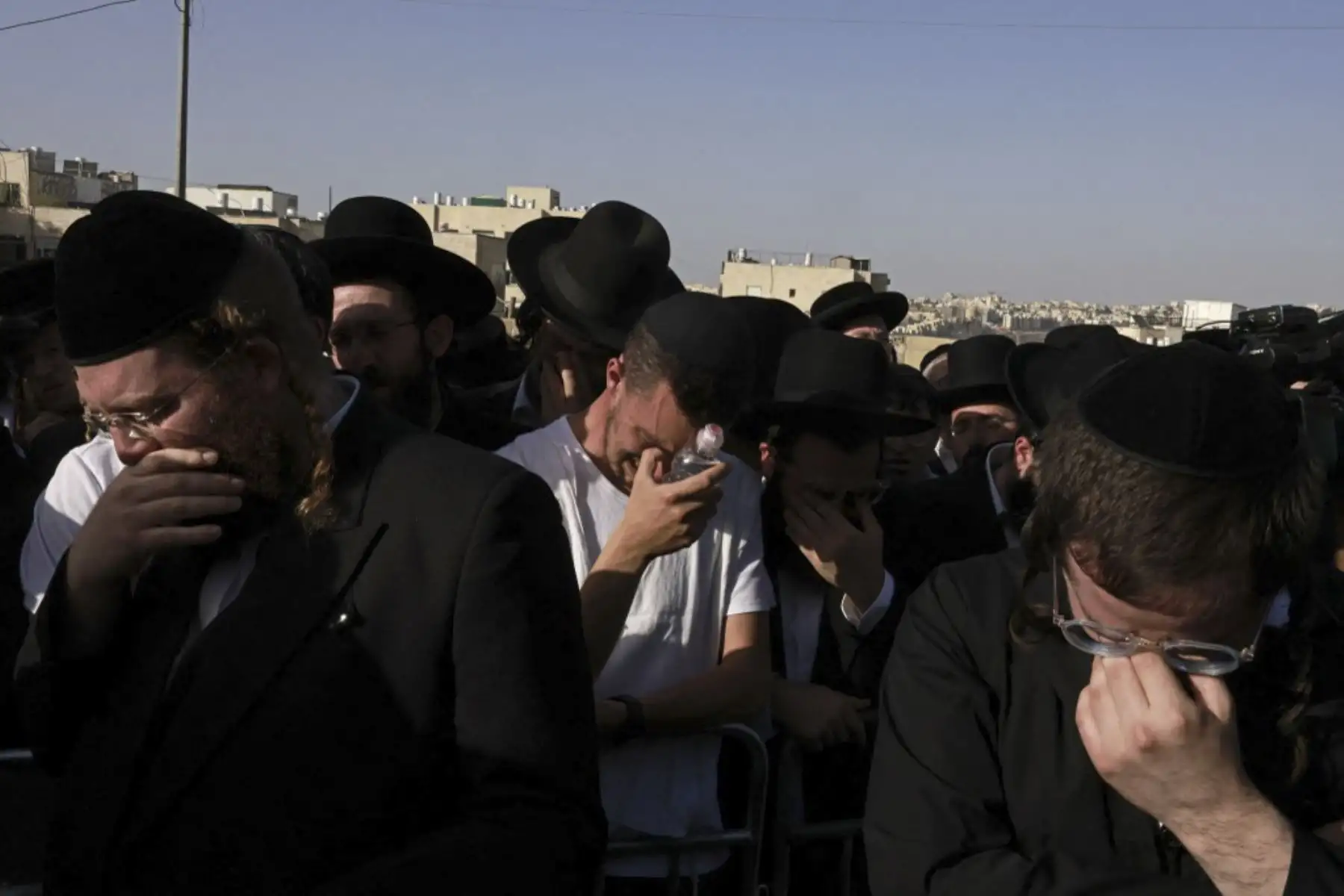 Hombres judíos ultraortodoxos lloran durante una ceremonia fúnebre en Jerusalén por una víctima de una estampida nocturna en un lugar de peregrinación judío, el 30 de abril de 2021. Foto: AFP