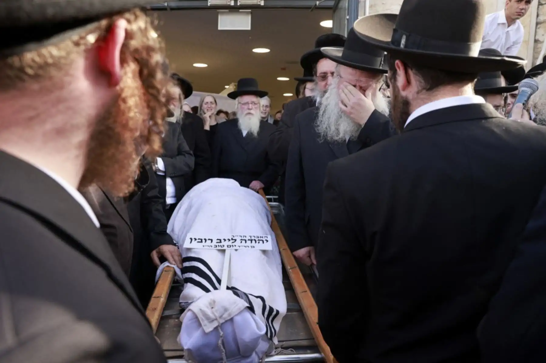 Los dolientes judíos ultraortodoxos llevan el cuerpo de una víctima de una estampida nocturna en un lugar de peregrinaje judío, durante una ceremonia fúnebre en Jerusalén el 30 de abril de 2021. Foto: AFP