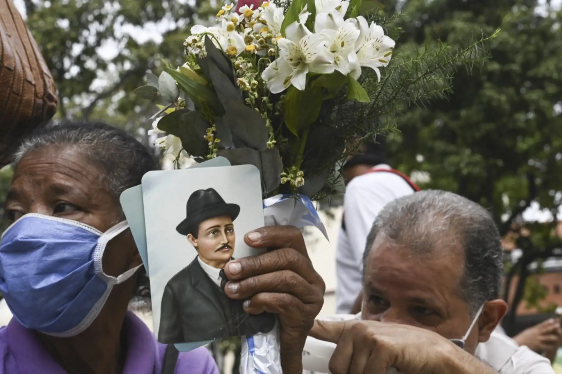 Una mujer sostiene una imagen del médico venezolano José Gregorio Hernández, también llamado "el médico de los pobres", durante su ceremonia de beatificación frente a la iglesia La Candelaria en Caracas el 30 de abril de 2021. Foto: AFP
