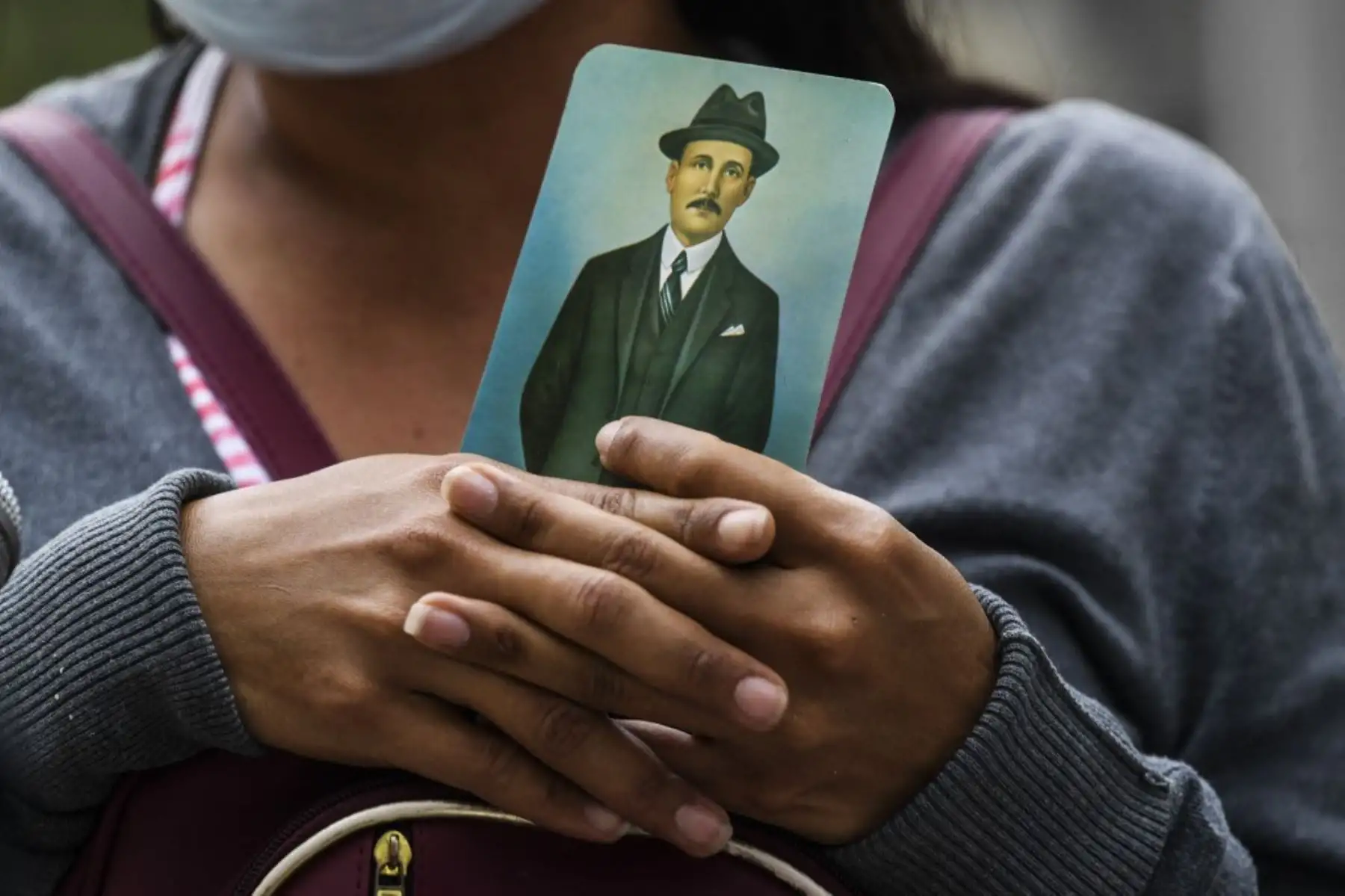Una mujer sostiene una imagen del médico venezolano José Gregorio Hernández, también llamado "el médico de los pobres", durante su ceremonia de beatificación frente a la iglesia La Candelaria en Caracas el 30 de abril de 2021. Foto: AFP