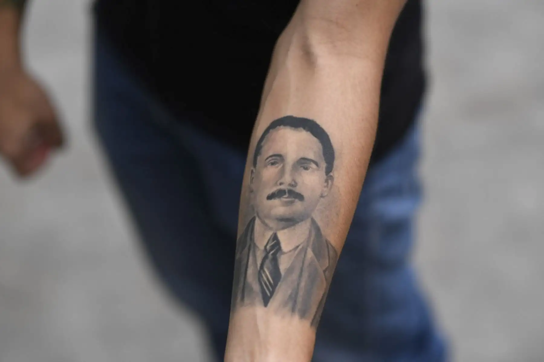 Un hombre muestra un tatuaje del médico venezolano José Gregorio Hernández, también llamado "el médico de los pobres" se devela durante la ceremonia de beatificación, frente a la iglesia La Candelaria en Caracas el 30 de abril de 2021. Foto: AFP