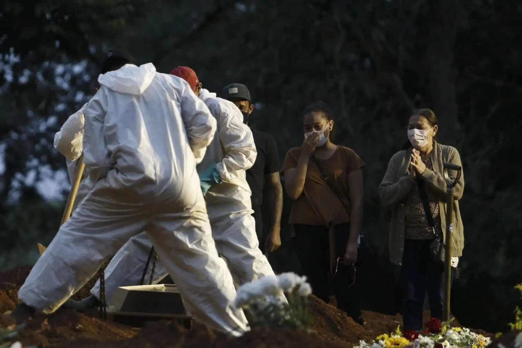 La gente llora mientras un familiar es enterrado por trabajadores del cementerio con equipo de protección como medida preventiva contra la propagación de la enfermedad del nuevo coronavirus, covid-19, en el cementerio de Vila Formosa en Sao Paulo, Brasil. Foto: AFP
