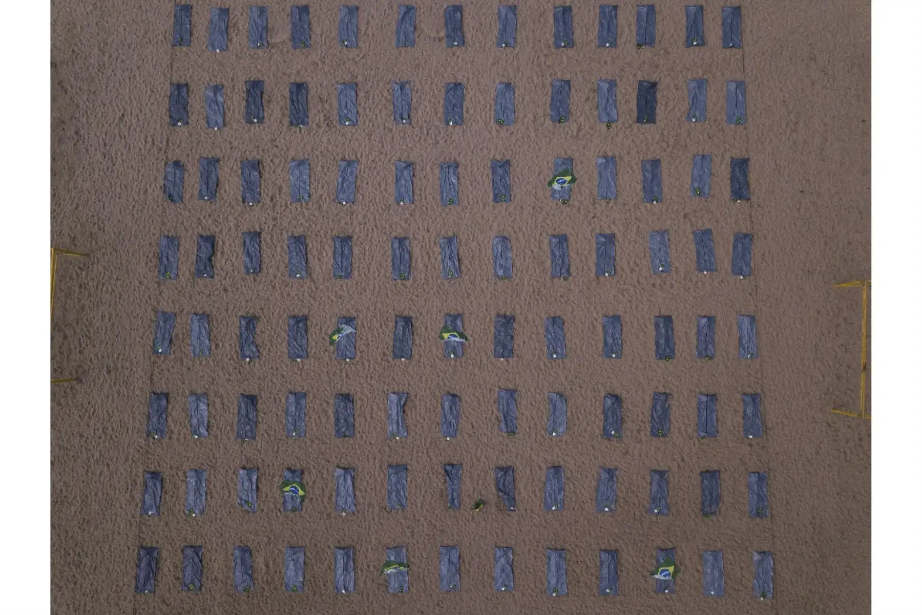 Esta imagen muestra filas de bolsas que simbolizan bolsas para cadáveres en la playa de Copacabana colocadas por activistas de los derechos humanos de Río de Paz durante una protesta contra el manejo del gobierno brasileño de la pandemia de coronavirus, en Río de Janeiro, Brasil. Foto: AFP