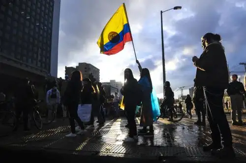 Una mujer ondea una bandera nacional de Colombia durante una protesta contra una reforma fiscal propuesta por el gobierno del presidente colombiano, Iván Duque, en Bogotá. Foto: AFP.