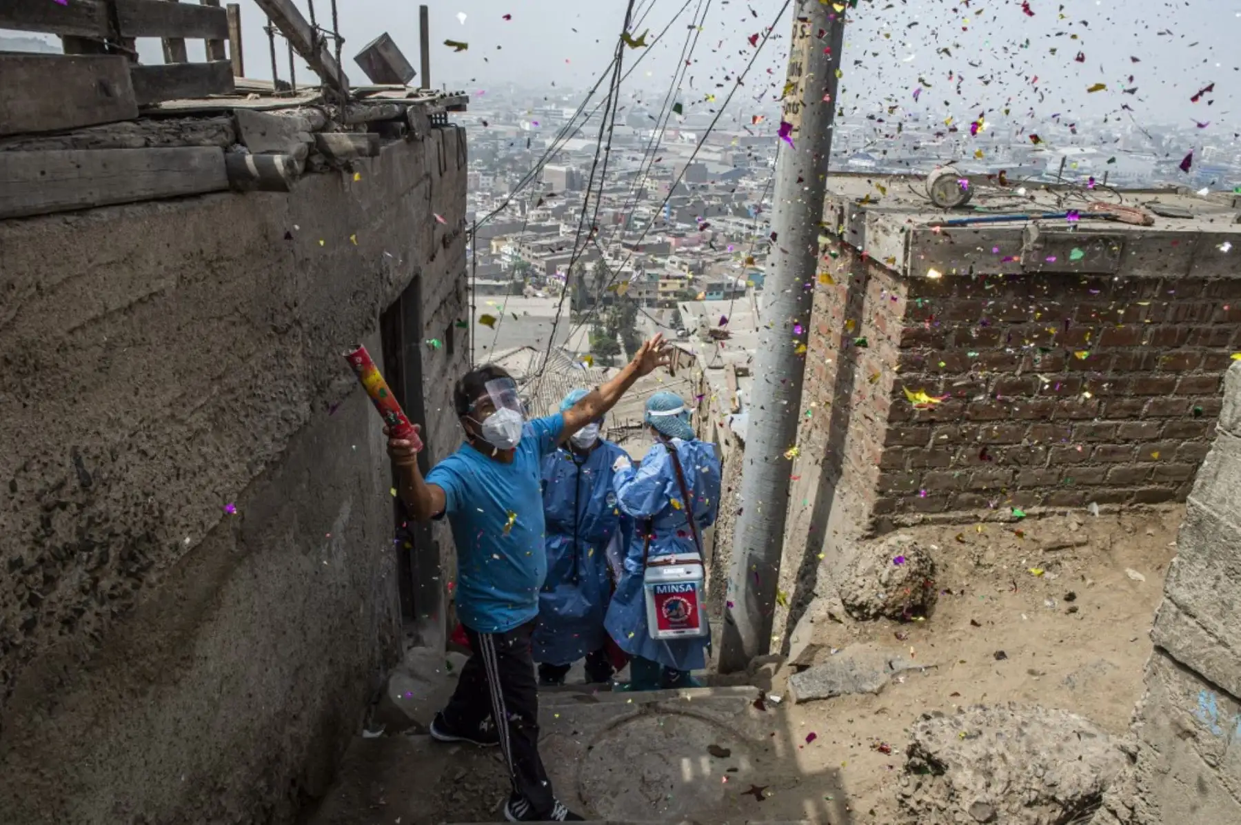 Un hombre celebra después de que los trabajadores de la salud inocularon a Maximiliana Quispe con una dosis de la vacuna Pfizer-BioNTech contra el covid-19, en su casa del distrito El Agustino de Lima. Foto: AFP