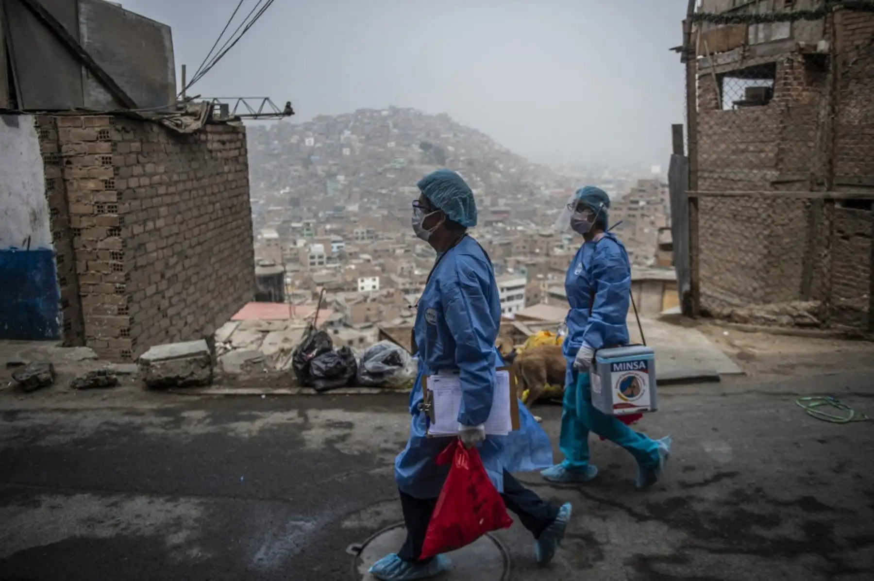 Trabajadores de salud llegan para inocular a ancianos con dosis de la vacuna Pfizer-BioNTech contra covid-19, a su casa del distrito El Agustino en Lima. Foto: AFP