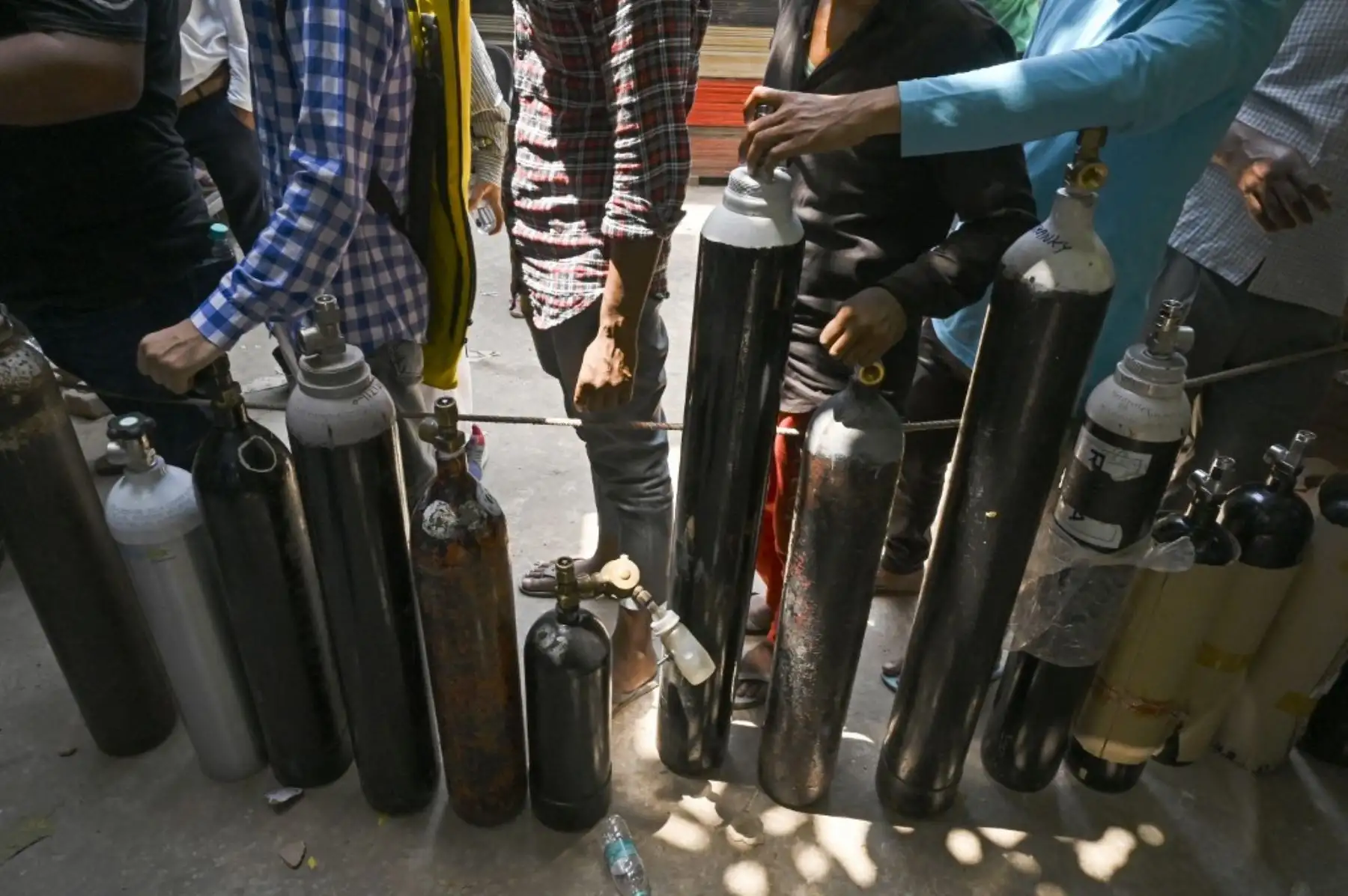 La gente espera en una fila para rellenar cilindros de oxígeno para pacientes con coronavirus Covid-19 en un centro de recarga en Nueva Delhi. Foto: AFP