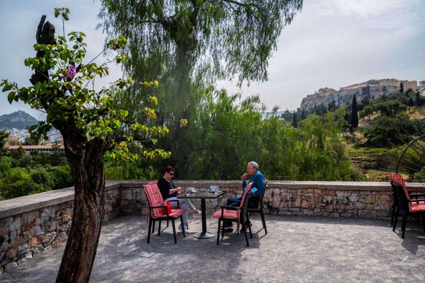 La gente se sienta en un café en Thiseio en Atenas, mientras los restaurantes y cafés en Grecia abren después de seis meses de cierre debido a la pandemia de covid-19. Foto: AFP
