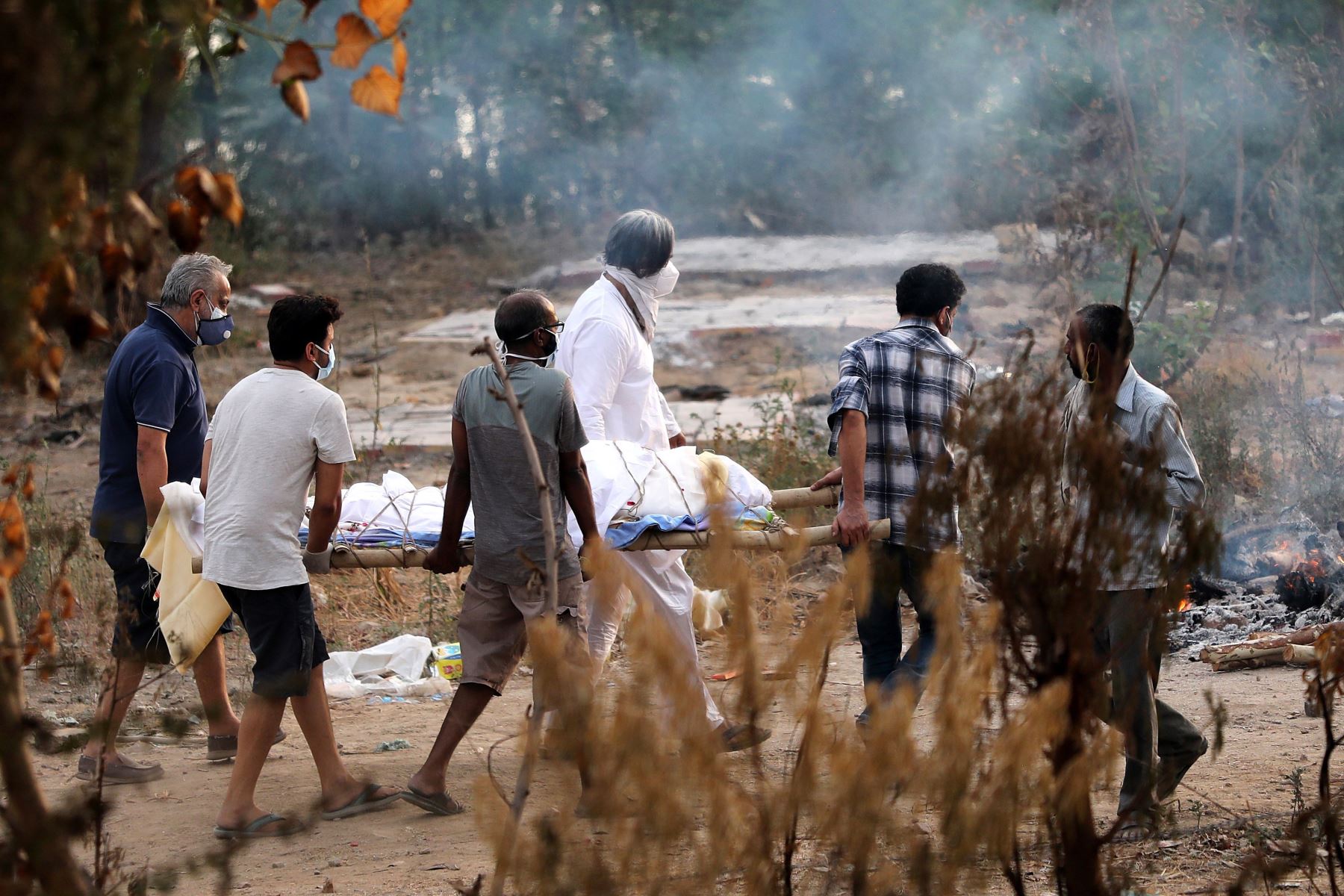 Personas llevan un cuerpo a una pira funeraria para los últimos ritos en un crematorio en Nueva Delhi, India, 04 de mayo de 2021. Foto: EFE