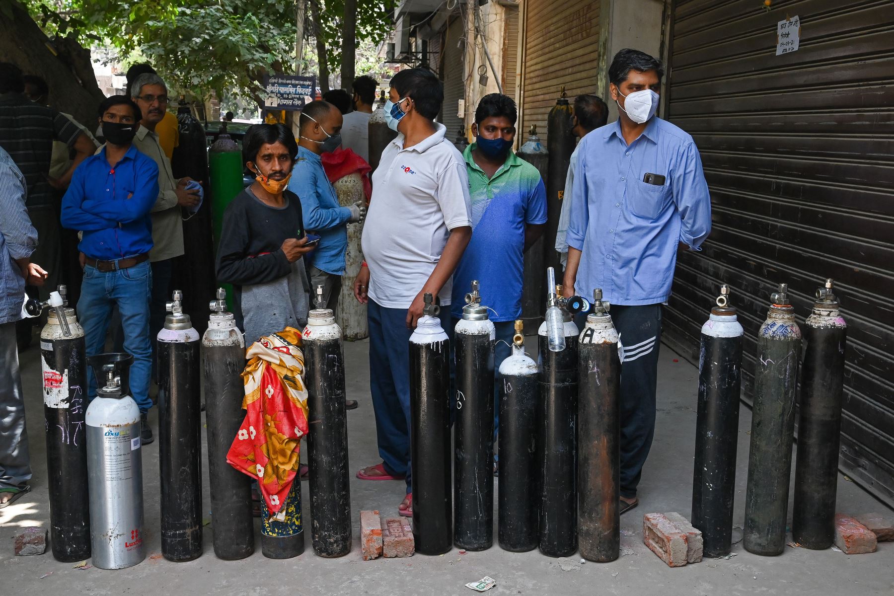 La gente espera para rellenar sus cilindros de oxígeno médico para los pacientes con coronavirus bajo cuarentena domiciliaria, en un centro de recarga privado en Nueva Delhi, el 4 de mayo de 2021. Foto: AFP