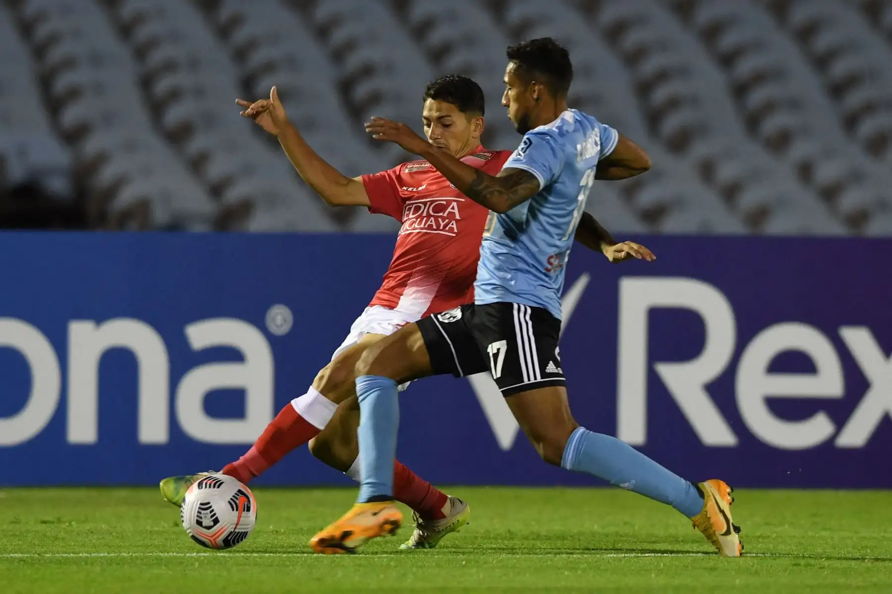 El uruguayo del club Rentistas Franco Pérez  y el peruano Sporting Cristal Christofer Gonzales compiten por el balón durante el partido de la fase de grupos del torneo de fútbol Copa Libertadores.
Foto: AFP