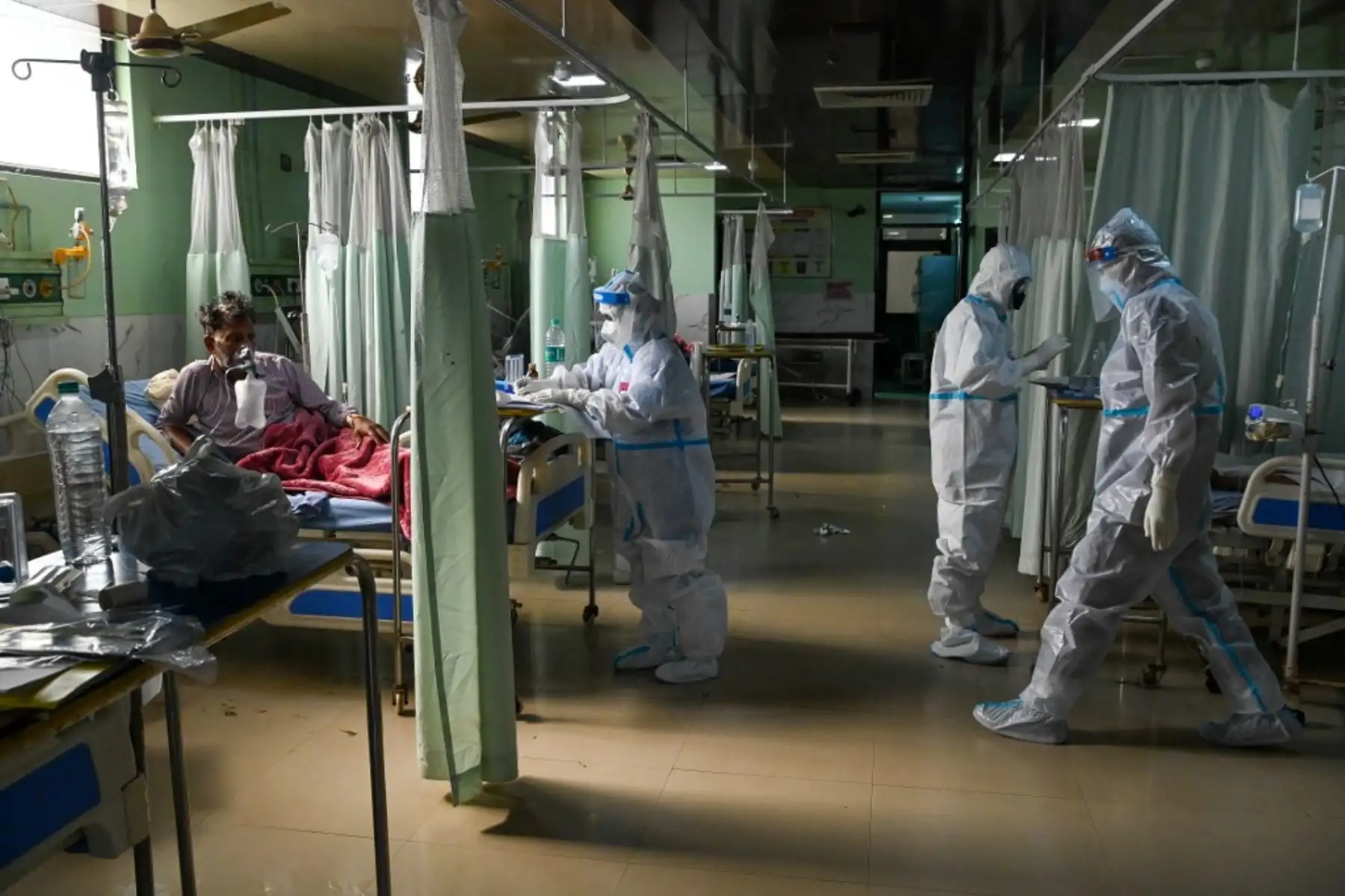Trabajadores de la salud que usan un equipo de protección personal (equipo de protección personal) atienden al paciente dentro de la Unidad de atención de incentivos (UCI) del hospital de la Universidad Teerthanker Mahaveer (TMU) en Moradabad. Foto: AFP