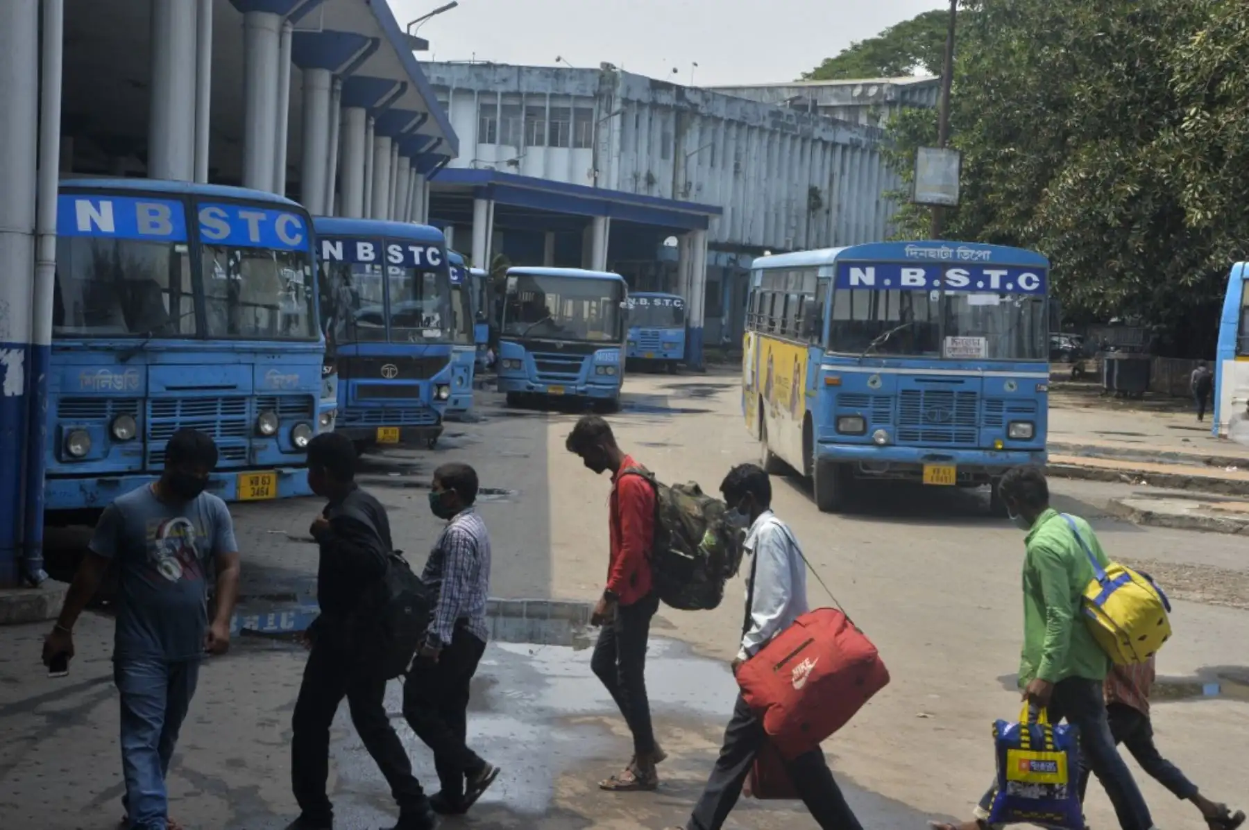 Los pasajeros caminan en la estación de la Corporación de Transporte del Estado de Bengala del Norte en Siliguri el 6 de mayo de 2021 luego del anuncio del departamento de estado de Bengala Occidental de servicios de autobús limitados en medio de la pandemia del coronavirus covid-19. Foto: AFP