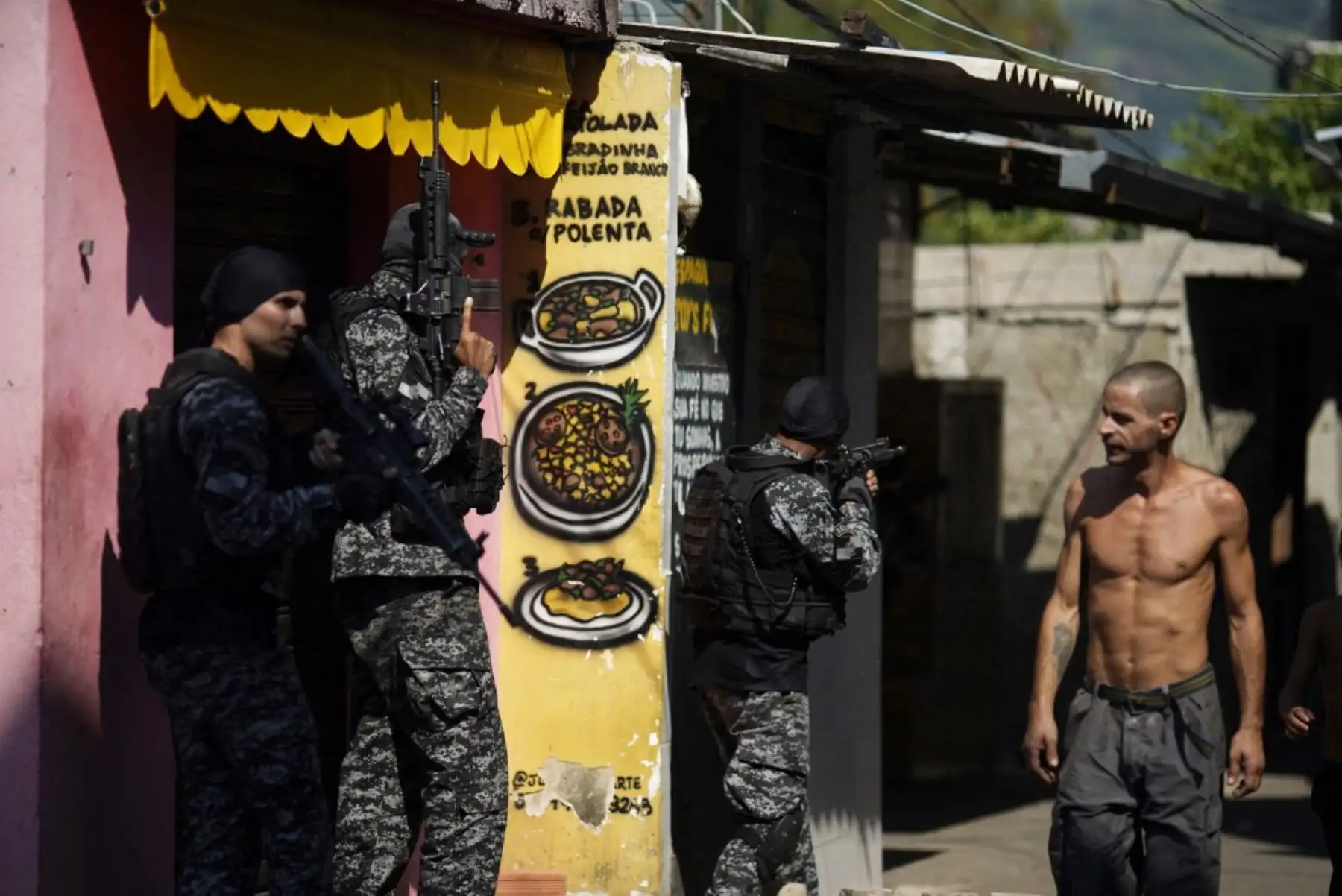 Un residente local observa a los agentes de la Policía Civil de Río que tomaron posición durante un operativo policial contra los narcotraficantes en la favela Jacarezinho en el estado de Río de Janeiro, Brasil, el 6 de mayo de 2021. Foto: AFP