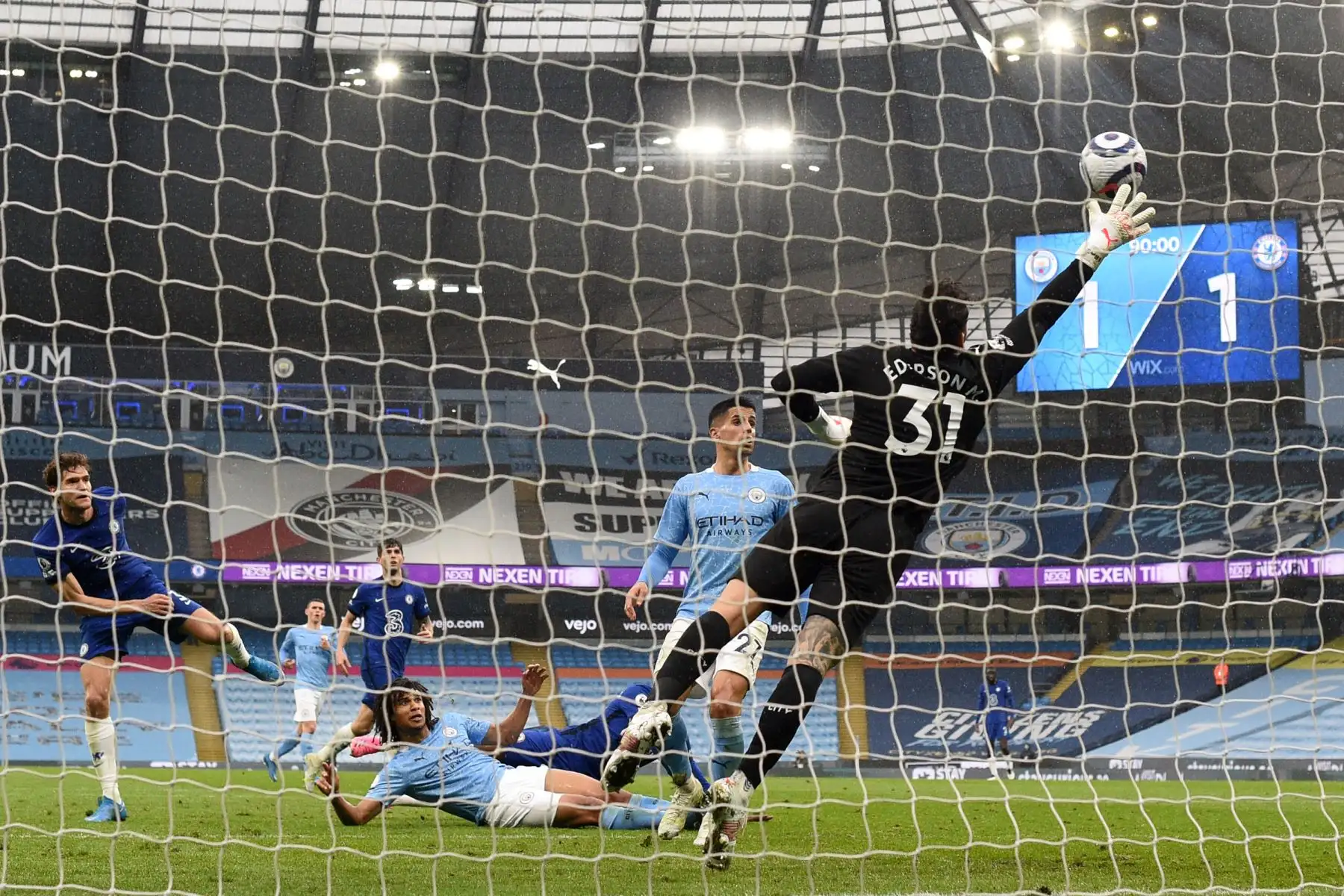 El defensor español del Chelsea, Marcos Alonso, dispara al portero brasileño del Manchester City, Ederson, para anotar su último gol de la victoria durante el partido de fútbol de la Premier League inglesa entre Manchester City y Chelsea.
Foto: AFP