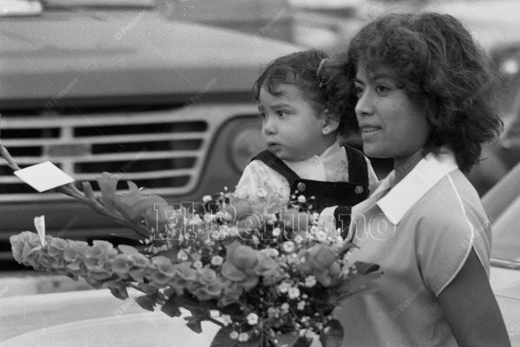 Lima - 10 mayo 1981 / Una joven mujer y su pequeña hija llevan un ramo de flores  por el Día de la Madre. Foto: Archivo Histórico de El Peruano / Normán Córdova
