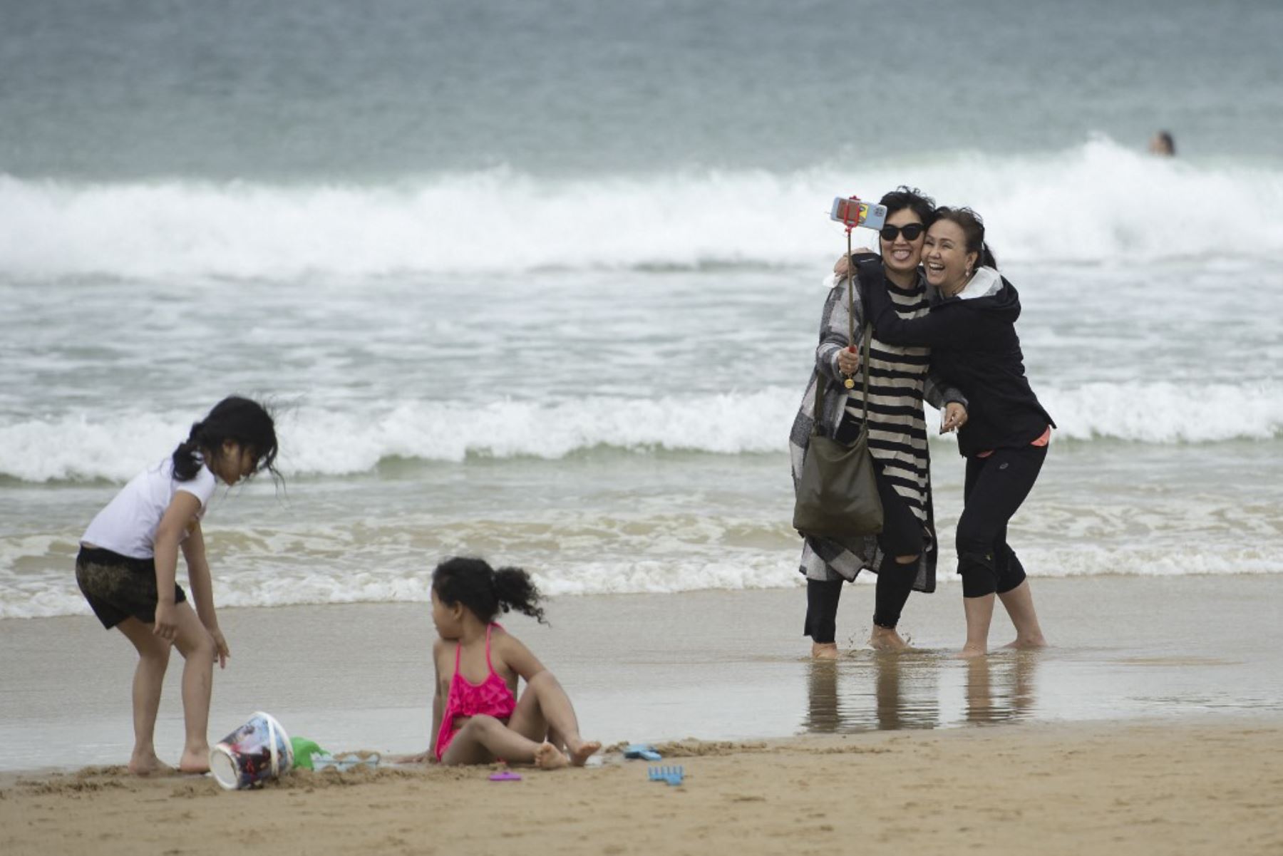 Dos mujeres sonríen mientras se toman una foto selfie en la playa de La Concha en San Sebastián. Foto: AFP