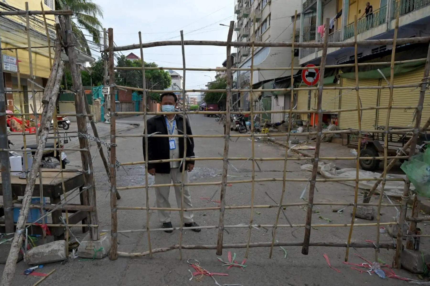 Un trabajador de la autoridad local hace guardia detrás de una barricada establecida debido a las restricciones de bloqueo introducidas para tratar de detener un aumento en los casos del coronavirus covid-19 en Phnom Penh. Foto: AFP