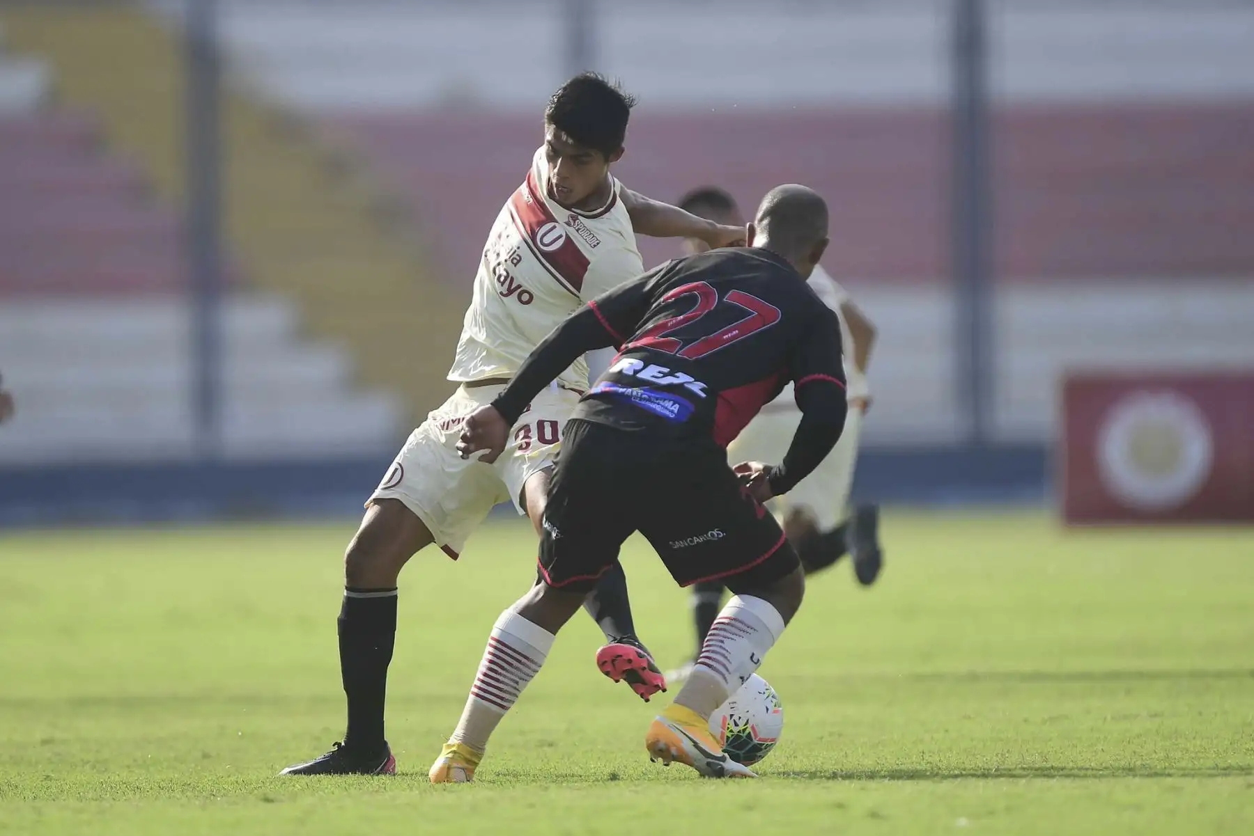 A. Osorio de Universitario lucha por el balón ante la marca de L. Trujillo de UTC durante partido por la fecha 3 de la Liga 1, en el estadio Iván Elías Moreno. Foto: Liga 1