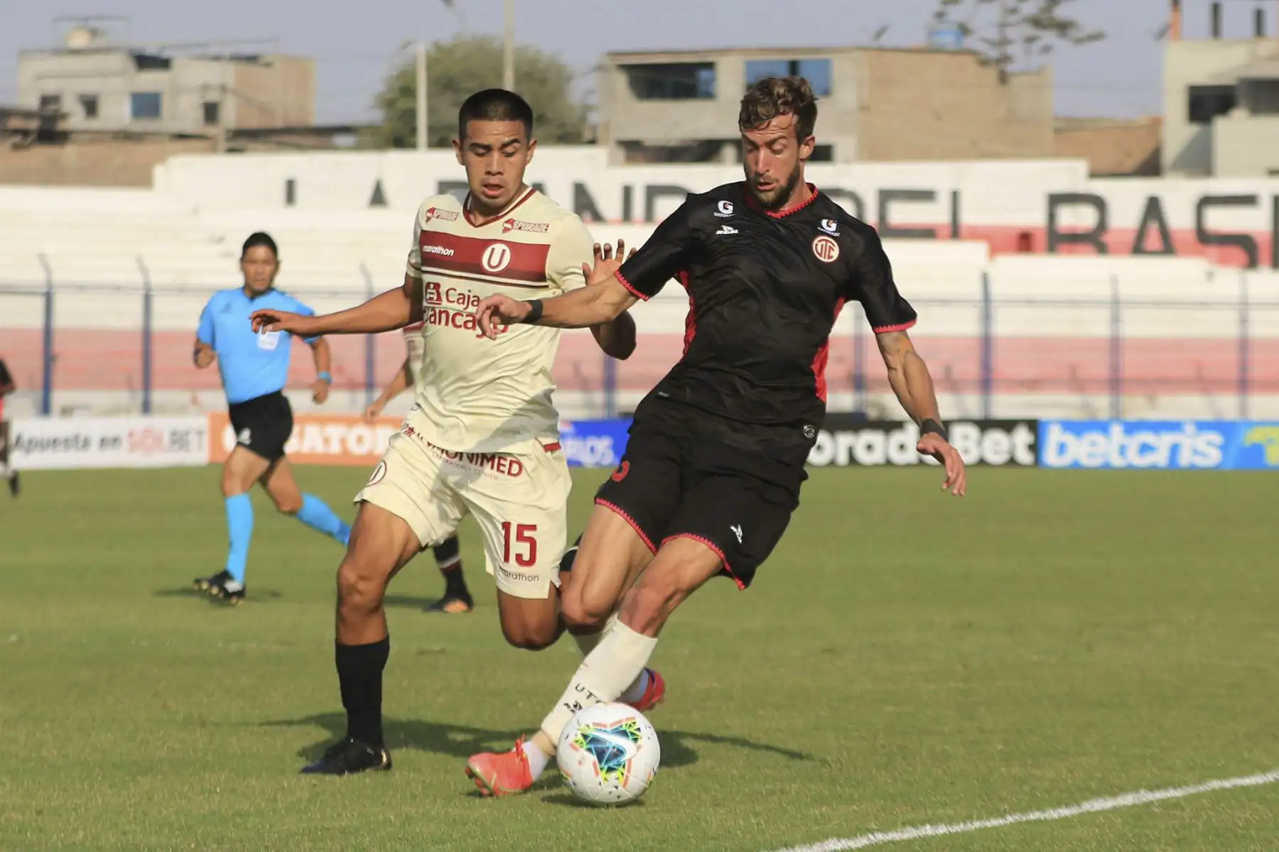 J. Zevallos de Universitario lucha por el balón ante la marca de su rival de UTC durante partido por la fecha 3 de la Liga 1, en el estadio Iván Elías Moreno. Foto: Liga 1