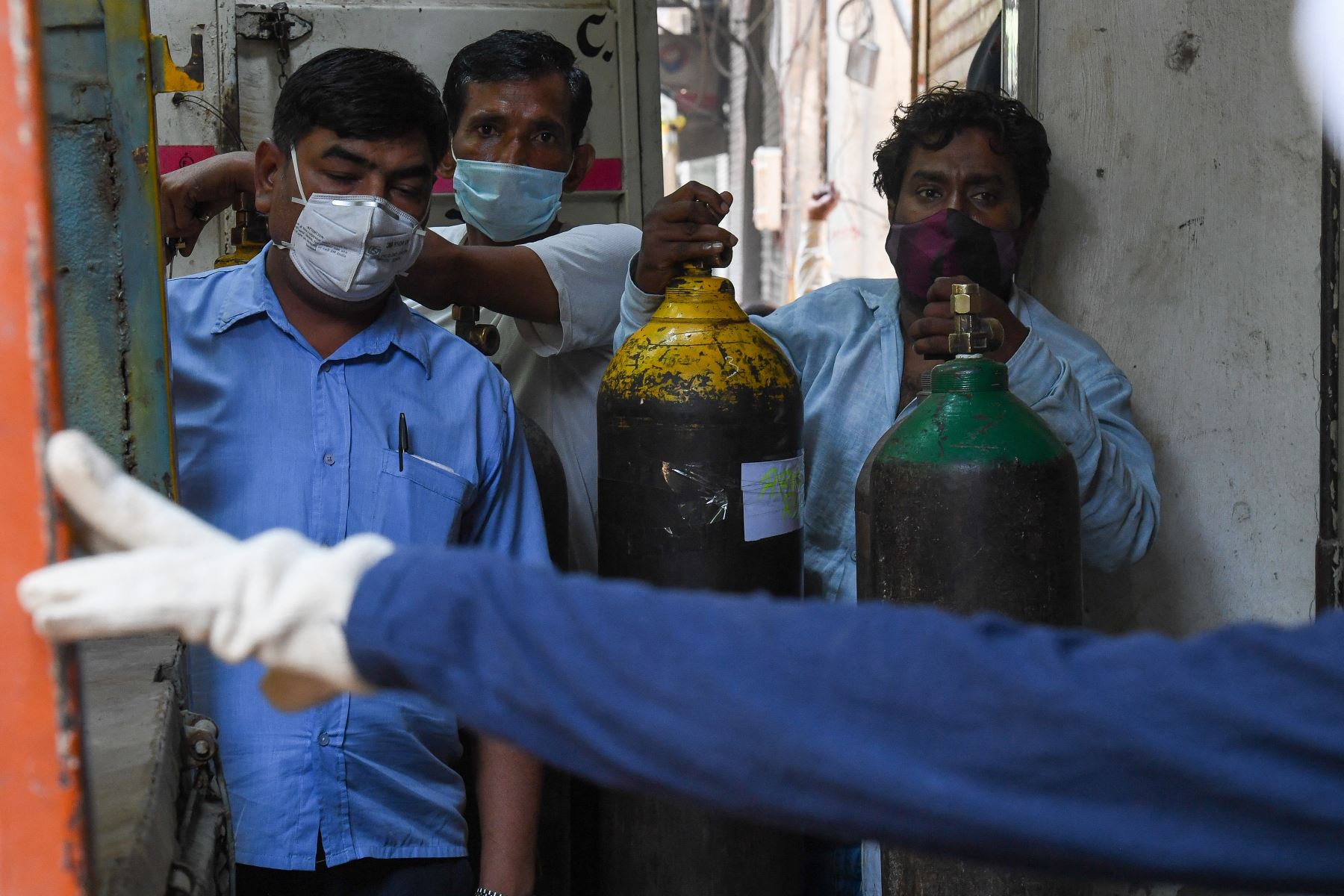 La gente espera para rellenar sus cilindros de oxígeno médico para los pacientes con Covid-19 bajo cuarentena domiciliaria en un centro de recarga privado, en Nueva Delhi, el 7 de mayo de 2021. Foto: AFP