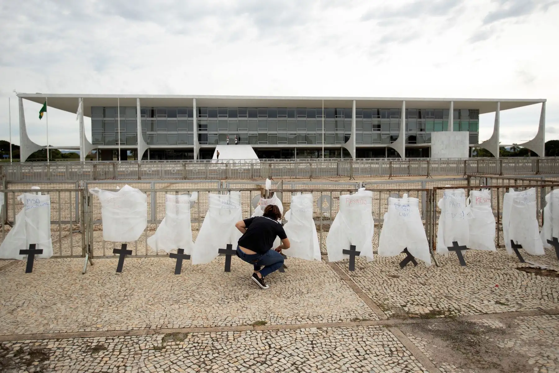 Una enfermera acomoda una cruz en una protesta simbólica en honor a los profesionales de la salud y por las más de 400.000 muertes por coronavirus, en Brasil. Foto: EFE
