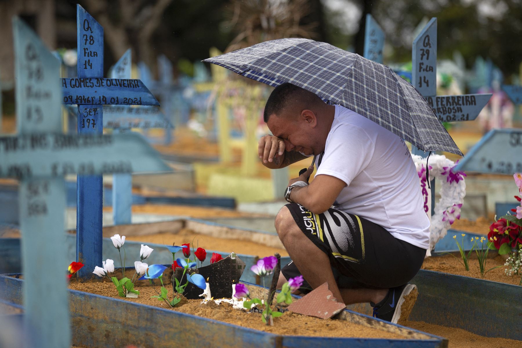 Un hombre llora junto a una tumba en el cementerio de Nossa Senhora Aparecida el Día de la Madre, en Manaus, estado de Amazonas, Brasil, el 9 de mayo de 2021. Foto: AFP