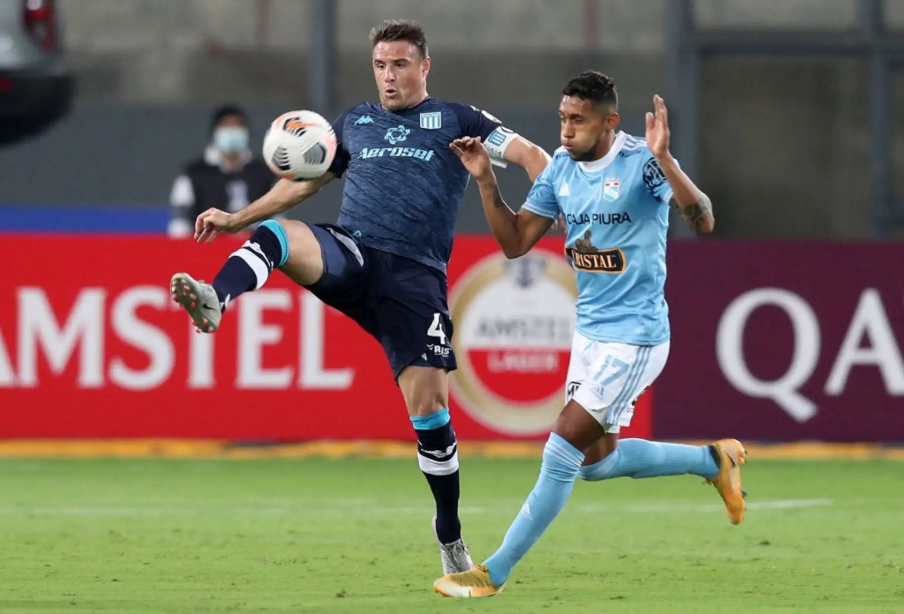 El jugador Christofer Gonzales del Sporting Cristal compiten por el balón, con Ivan Pillud de El Racing Club de Argentina, durante el partido de fútbol por La Copa Libertadores en el Estadio Nacional de Lima. Foto: AFP