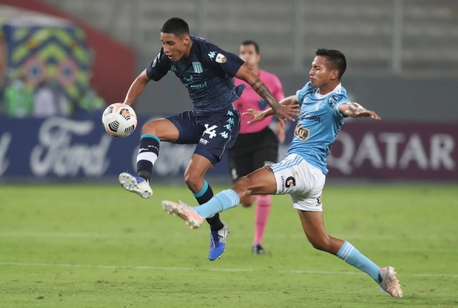 El jugador Gerald Tavara del Sporting Cristal compiten por el balón, con Julián López de El Racing Club de Argentina, durante el partido de fútbol por La Copa Libertadores en el Estadio Nacional de Lima. Foto: AFP