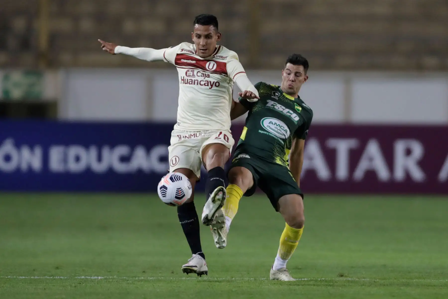 Alex Valera de Universitario disputa un balón con Fernando Meza de Defensa y Justicia  en un partido de la Copa Libertadores entre Universitario y Defensa y Justicia en el estadio Monumental U en Lima.
Foto: EFE