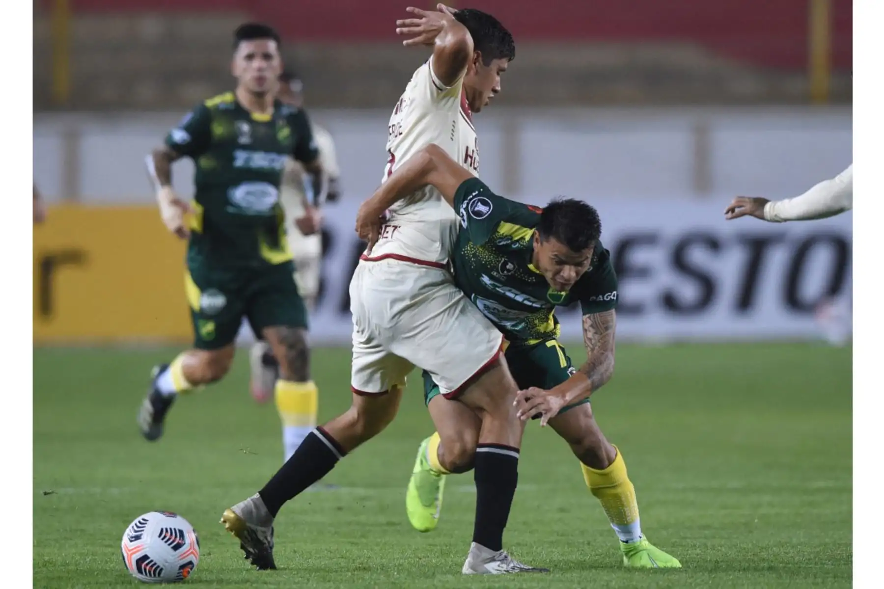 Luis Valverde de Universitario disputa un balón con Fernando Meza  de Defensa y Justicia, en un partido de la Copa Libertadores entre Universitario y Defensa y Justicia en el estadio Monumental en Lima. Foto: AFP