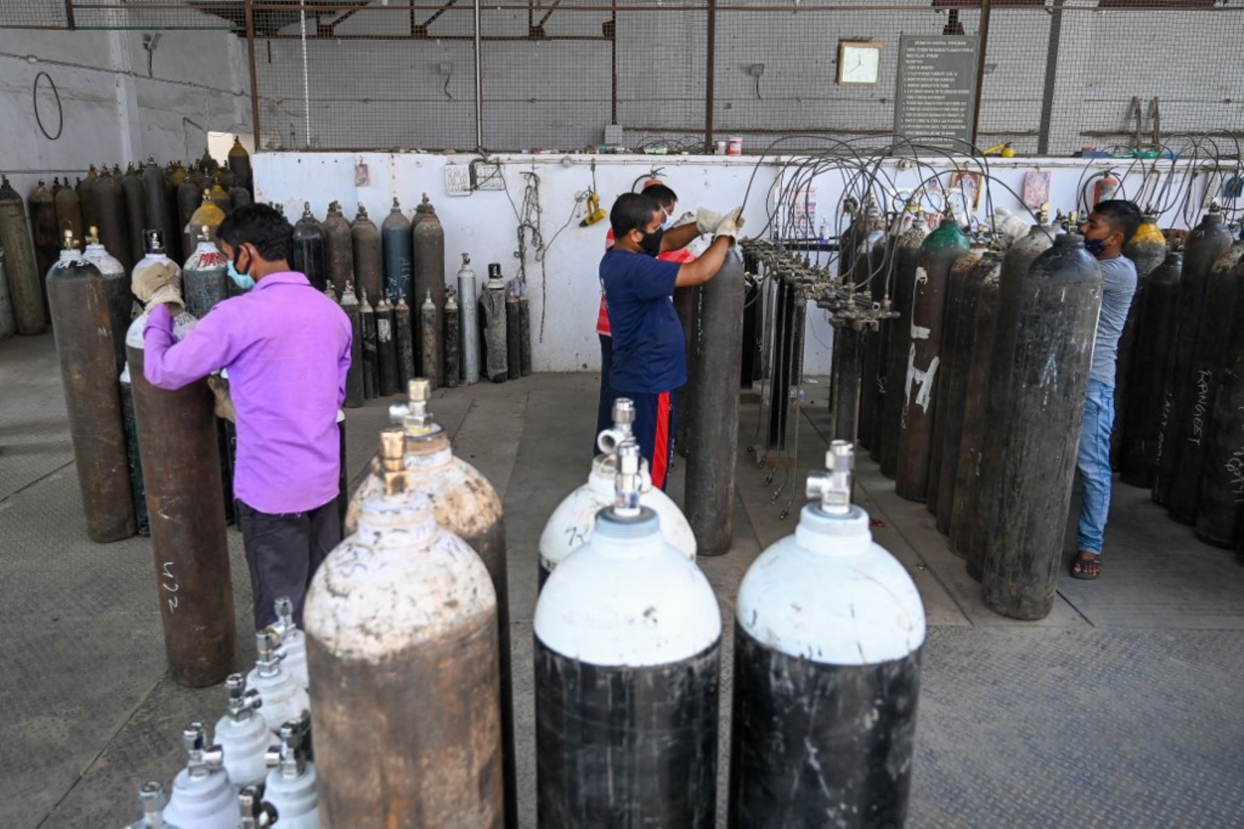 Los empleados rellenan cilindros con oxígeno médico para pacientes con coronavirus Covid-19 en un centro de recarga privado en Nueva Delhi. Foto: AFP