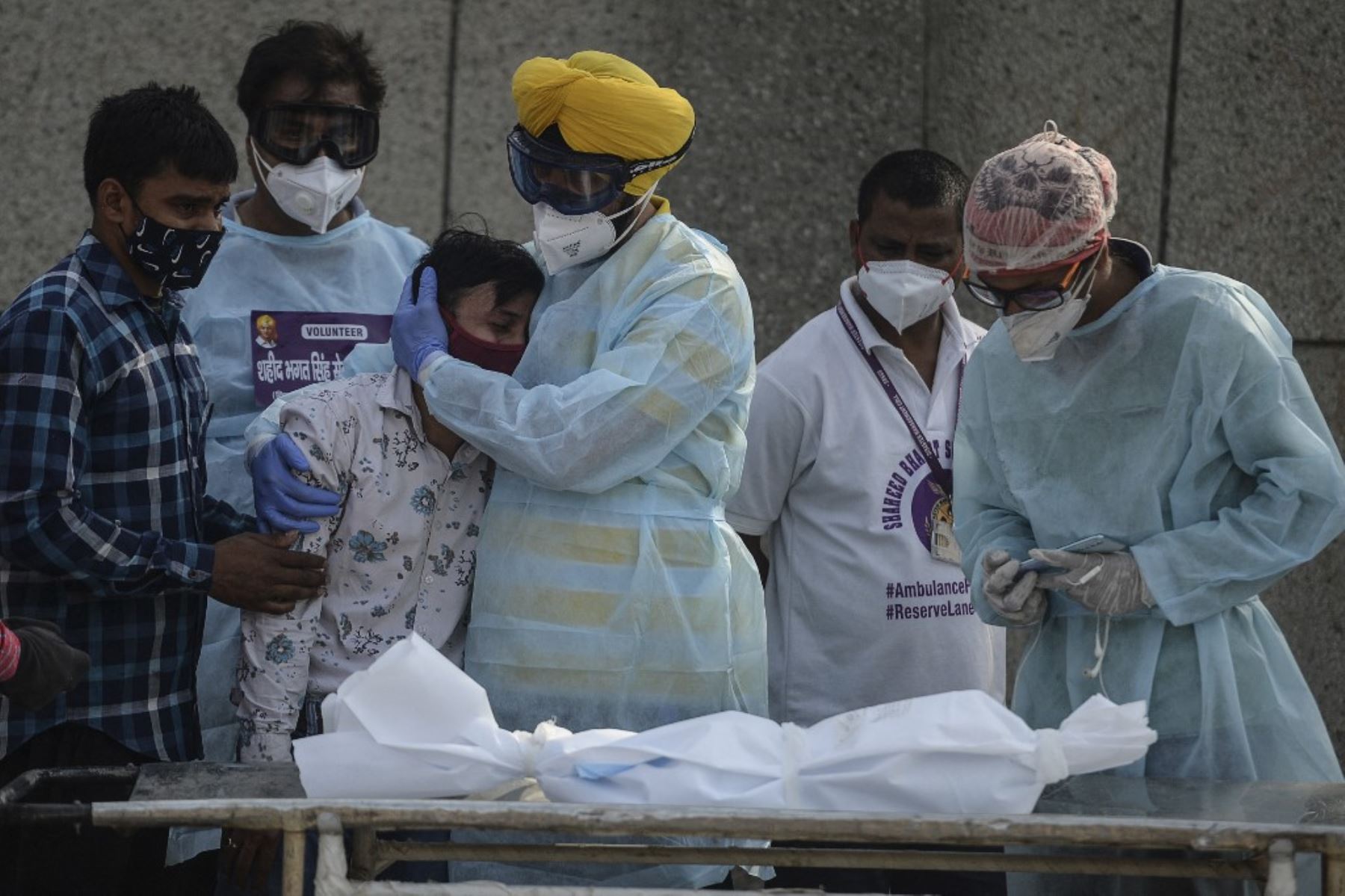 En esta fotografía, un voluntario consuela a un familiar de un niño que murió debido al coronavirus Covid-19 en un crematorio en Nueva Delhi. Foto: AFP