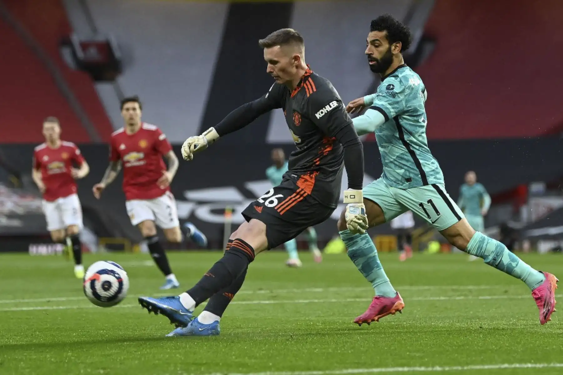 El mediocampista egipcio del Liverpool, Mohamed Salah (derecha), presiona al portero inglés del Manchester United, Dean Henderson, durante el partido de fútbol de la Premier League inglesa entre el Manchester United y el Liverpool en Old Trafford en Manchester, noroeste de Inglaterra. Foto: AFP