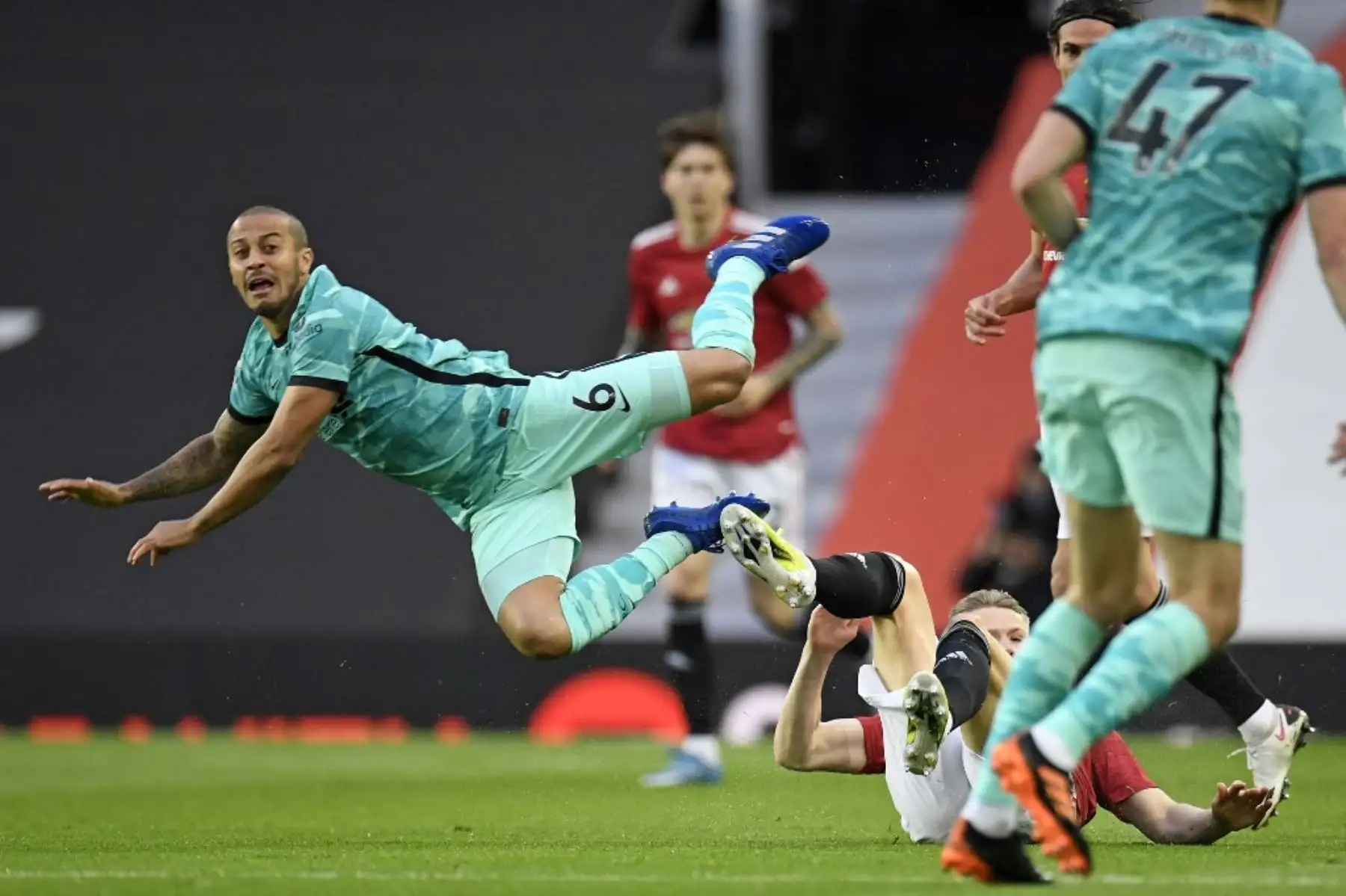 El mediocampista español del Liverpool, Thiago Alcántara, es abordado por el mediocampista escocés del Manchester United Scott McTominay durante el partido de fútbol de la Premier League inglesa entre el Manchester United y el Liverpool en Old Trafford en Manchester, noroeste de Inglaterra, el 13 de mayo de 2021. Foto: AFP