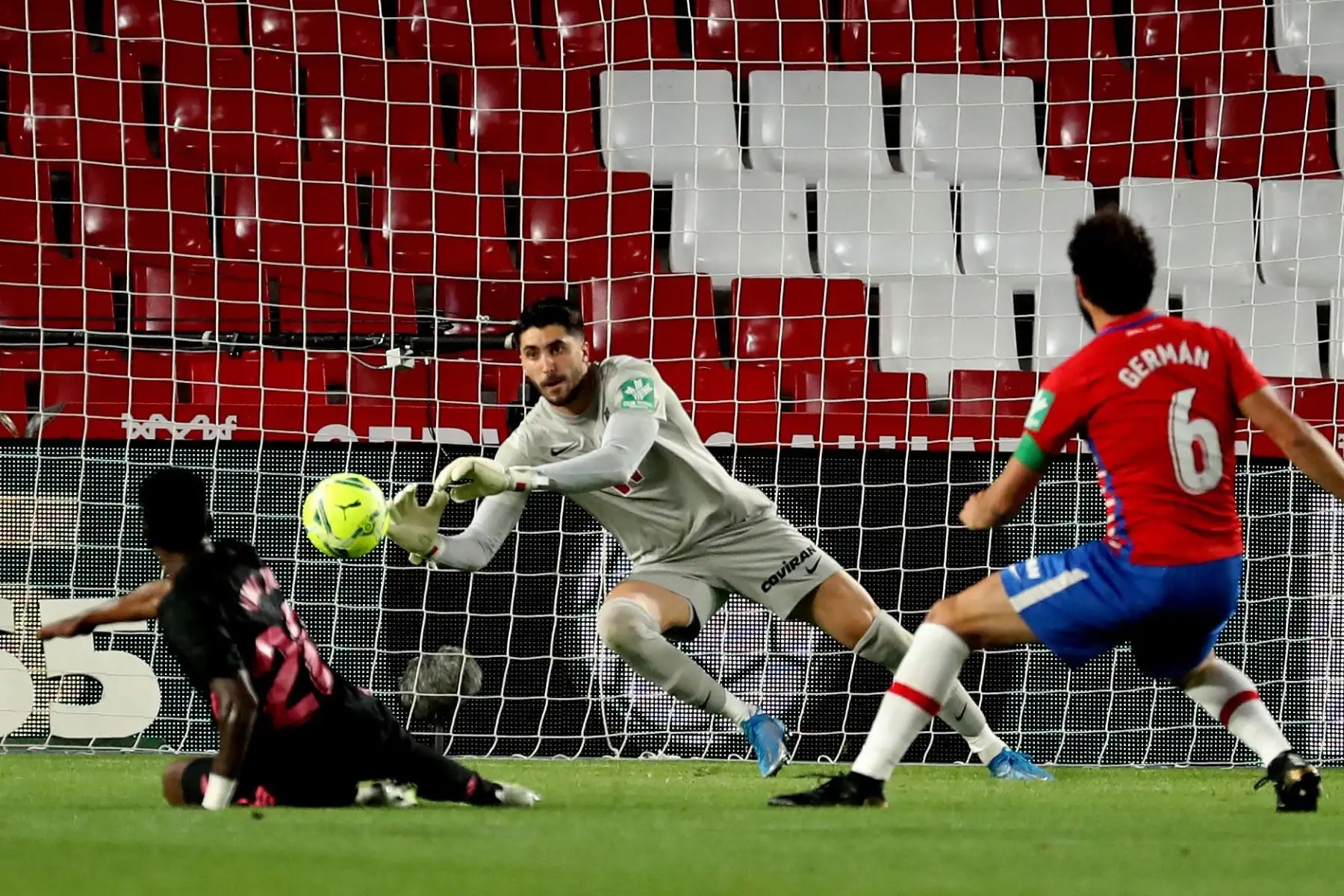 El delantero brasileño del Real Madrid, Vinicius Jr., remata ante el guardameta portugués del Granada, Rui Silva, durante partido por la Liga, en el estadio Nuevo Los Cármenes. Foto: EFE