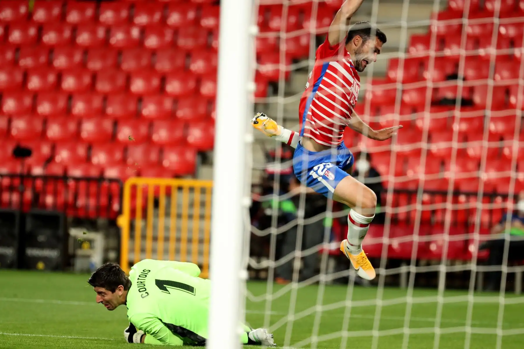 El delantero del Granada, Jorge Molina, salta ante el guardameta belga del Real Madrid, Thibaut Courtois, durante durante partido por la Liga, en el estadio Nuevo Los Cármenes. Foto: EFE