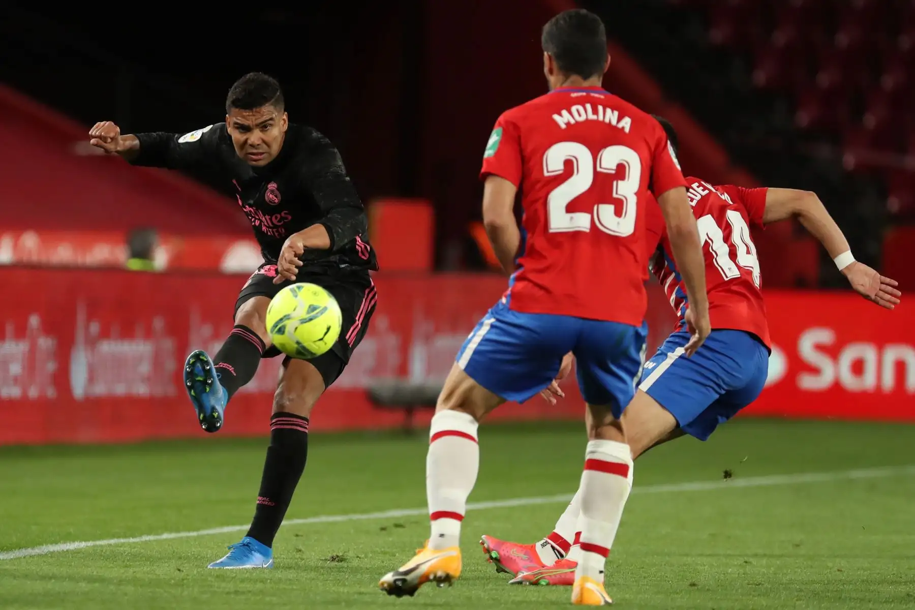 El centrocampista brasileño del Real Madrid, Carlos Henrique Casemiro, dispara el balón ante los jugadores del Granada, Jorge Molina y Fede Vico, durante encuentro por la Liga, en el estadio Nuevo Los Cármenes. Foto: EFE
