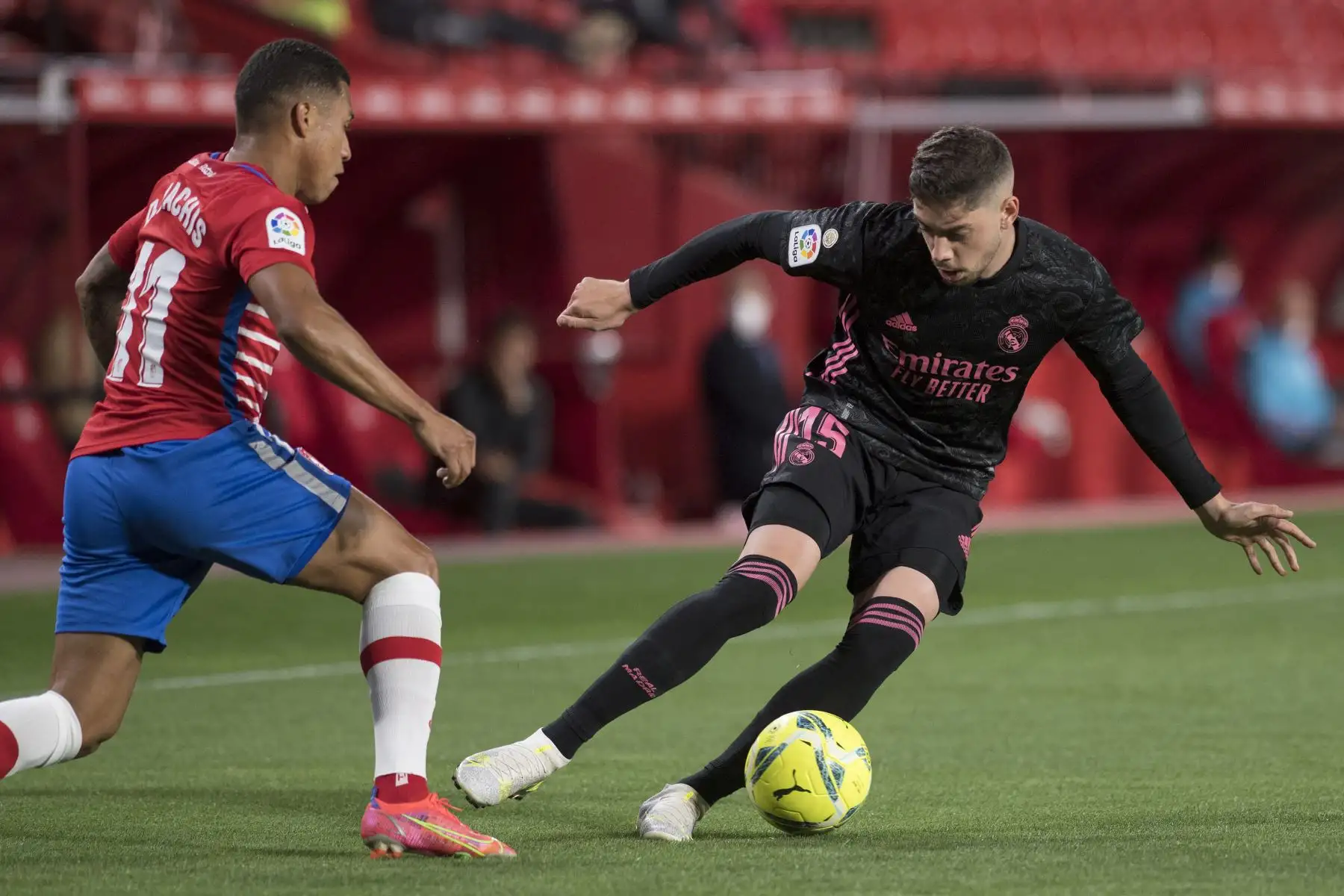 El delantero venezolano del Granada, Darwin Machis,  compite con el centrocampista uruguayo del Real Madrid, Federico Valverde, durante el partido de fútbol de la liga española. Foto: AFP