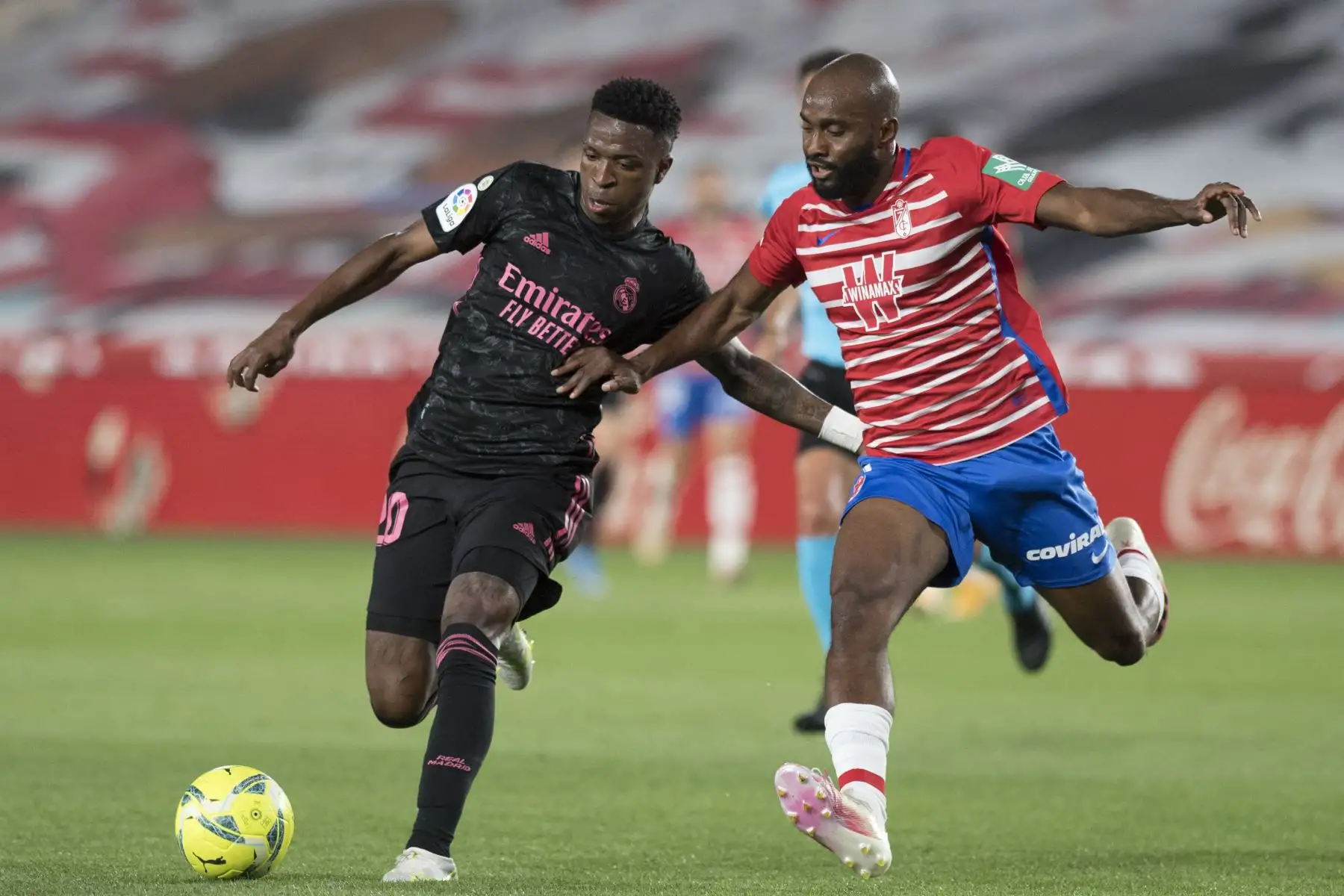 El delantero brasileño del Real Madrid, Vinicius Junior,  compite con el defensa francés del Granada, Dimitri Foulquier, durante el partido de fútbol de la liga española. Foto: AFP