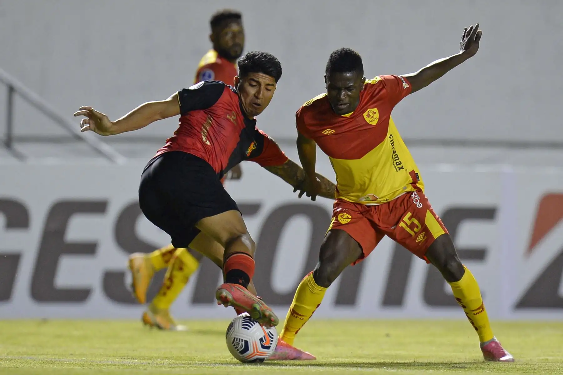El peruano Melgar Luis Iberico y el ecuatoriano de Aucas, Alex Carrera, disputan el balón durante el partido de la fase de grupos de la Copa Sudamericana,  en el estadio Gonzalo Pozo de Quito. Foto: AFP