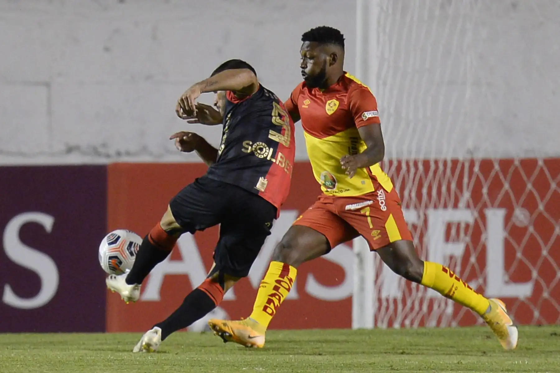 El argentino Bernardo Cuesta de Melgar y Harold González de Aucas compiten por el balón durante el partido de la fase de grupos de la Copa Sudamericana, en el estadio Gonzalo Pozo de Quito. Foto. AFP