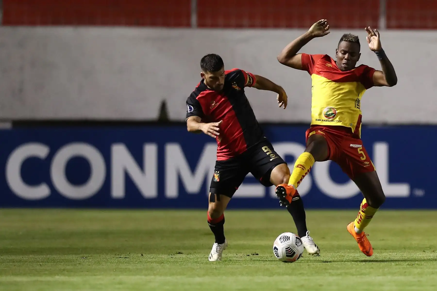 Franklin Carabalí de Aucas disputa un balón con Bernardo Cuesta de Melgar durante partido por la Copa Sudamericana en el estadio Chillogallo en Quito. Foto: EFE