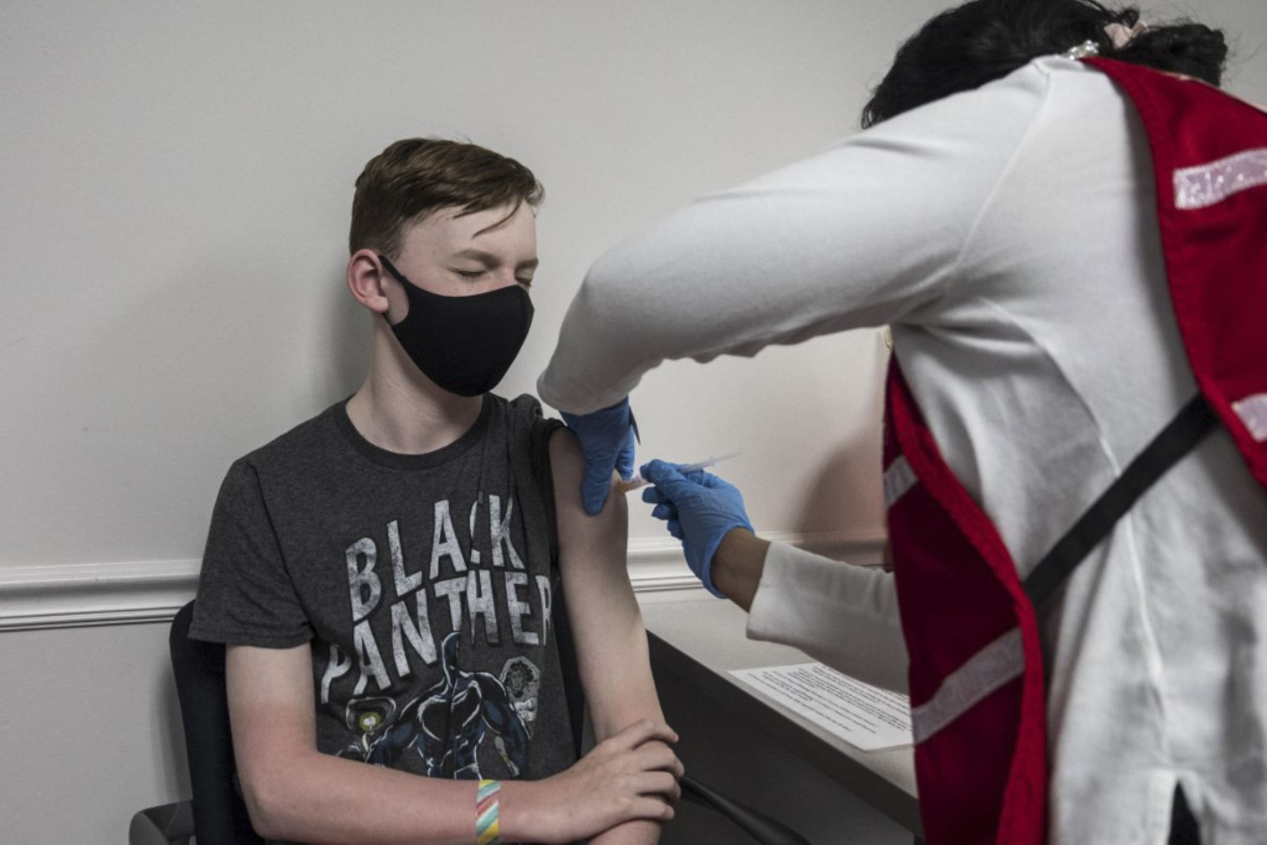 Luke Allan, de 13 años, cierra los ojos mientras recibe la vacuna Covid-19 en la clínica de vacunación del Fairfax Government Center en Fairfax, Virginia. Foto: AFP