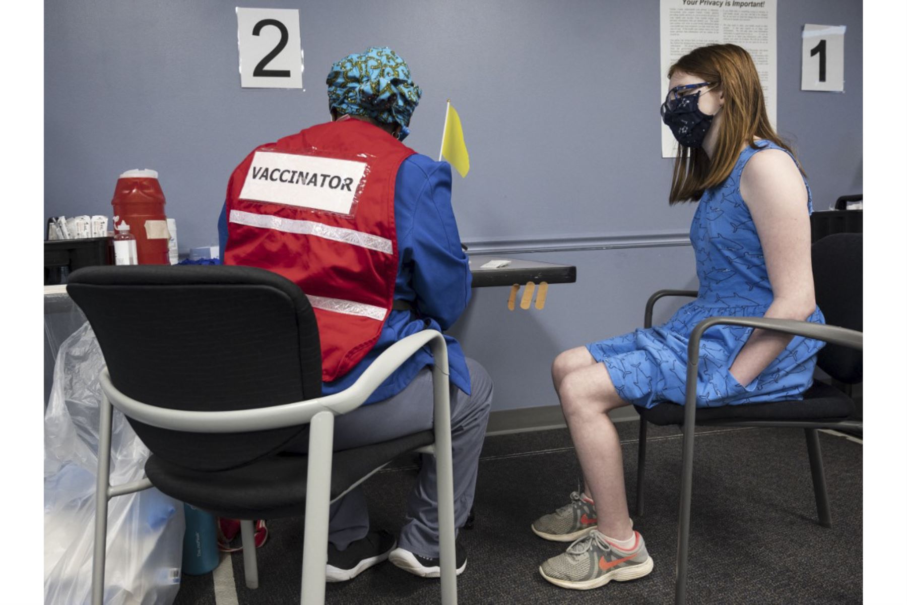 Claire, de 13 años, observa mientras se prepara para vacunarse contra el Covid-19 en la clínica de vacunación del Fairfax Government Center en Fairfax, Virginia. Foto: AFP