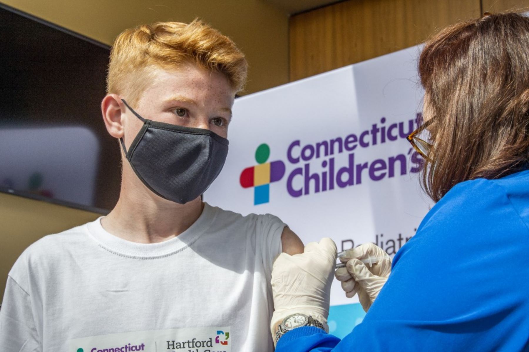 Robert Riccoban, de 13 años, es inoculado por la enfermera Karen Pagliaro en el centro de vacunación masiva de Hartford Healthcare en el Centro de Convenciones de Connecticut en Hartford, Connecticut. Foto: AFP