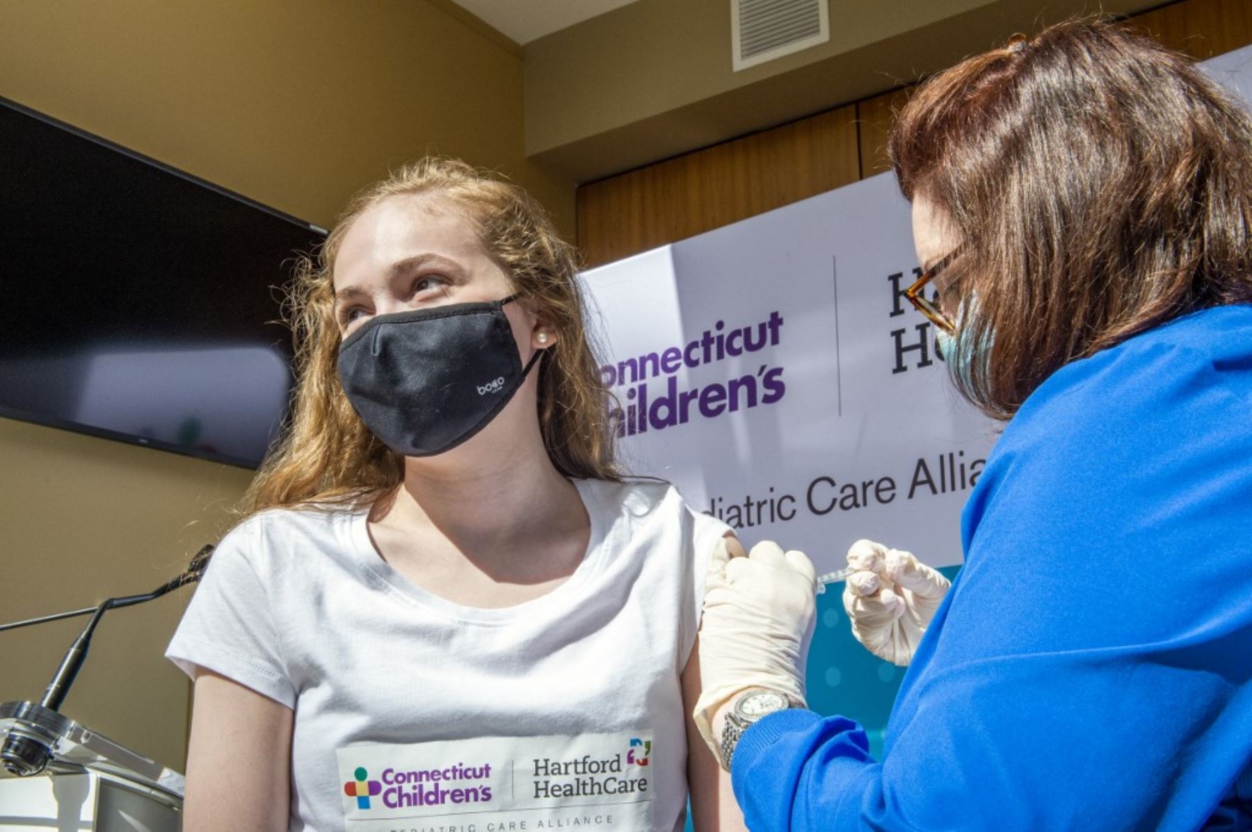 Ruthie Riccoban, de 14 años, es inoculada por la enfermera Karen Pagliaro en el centro de vacunación masiva de Hartford Healthcare en el Centro de Convenciones de Connecticut en Hartford, Connecticut. Foto: AFP