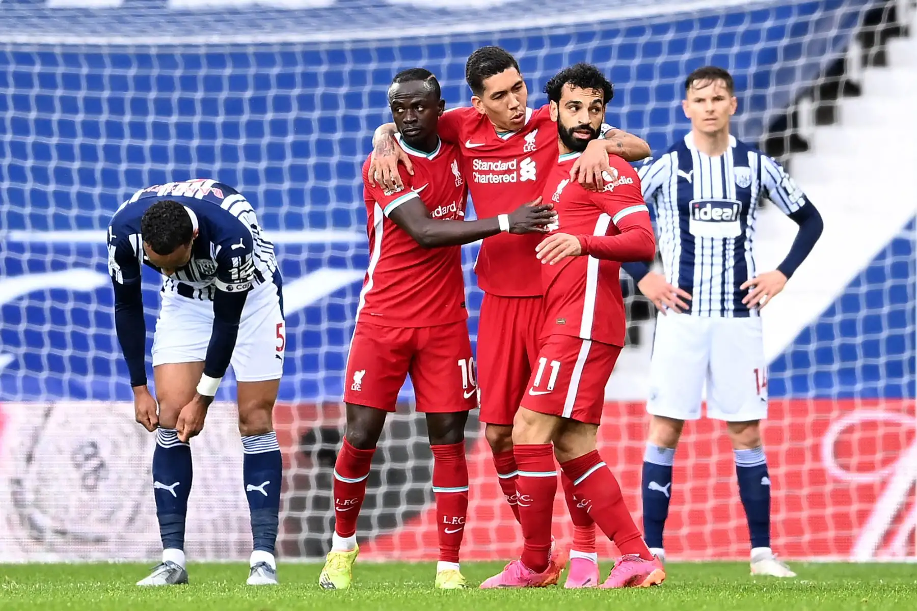 El centrocampista egipcio del Liverpool Mohamed Salah celebra anotar el primer gol de su equipo con el centrocampista brasileño del Liverpool Roberto Firmino y el delantero senegalés del Liverpool Sadio Mane durante el partido de fútbol de la Premier League inglesa entre West Bromwich Albion y Liverpool. Foto: AFP