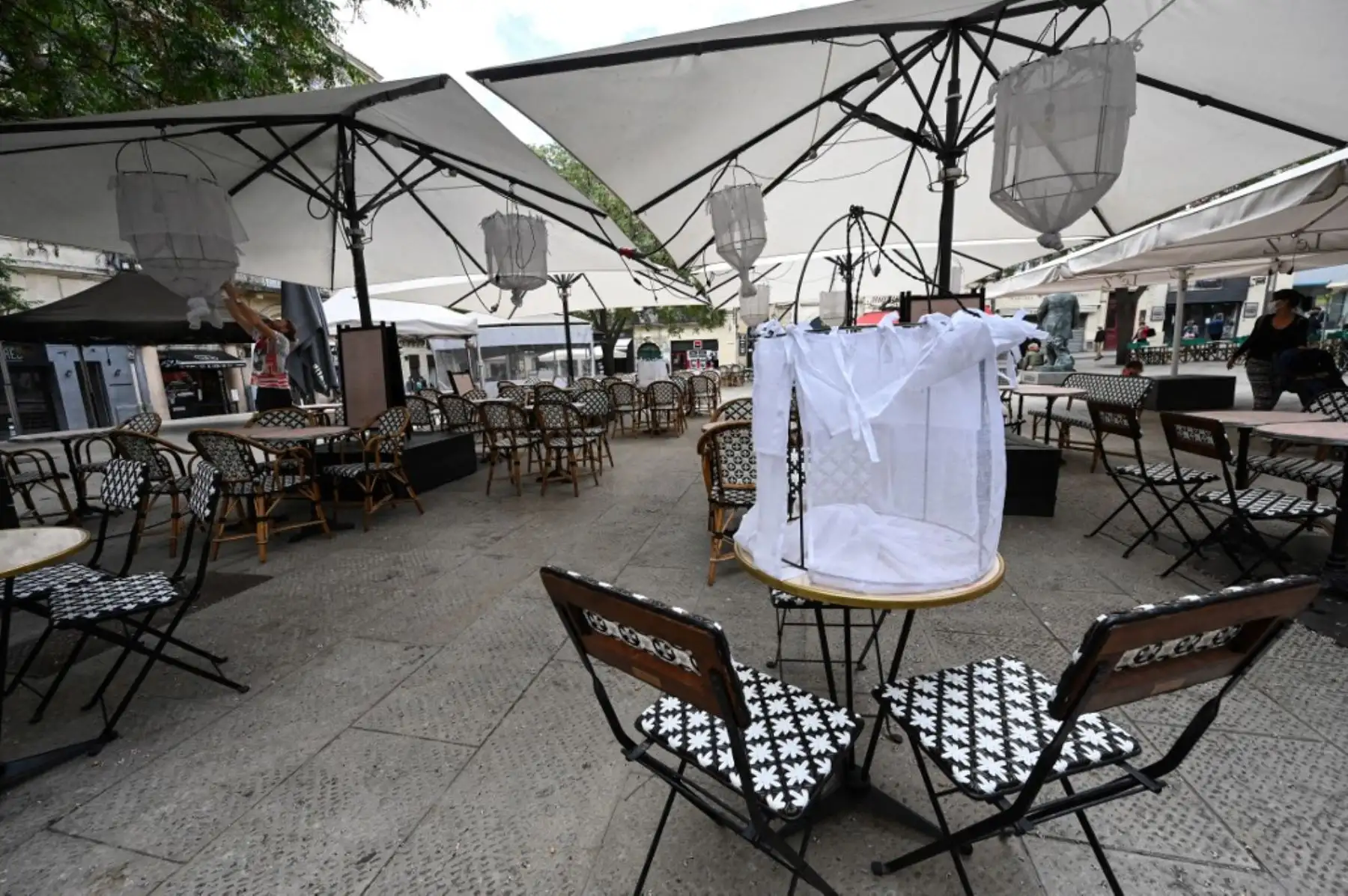 Un hombre instala la terraza de un restaurante en la ciudad de Montpellier, en el sur de Francia, el 17 de mayo de 2021, dos días antes de una reapertura enormemente anticipada de las terrazas de los restaurantes, como parte de un alivio del cierre nacional. Foto: AFP