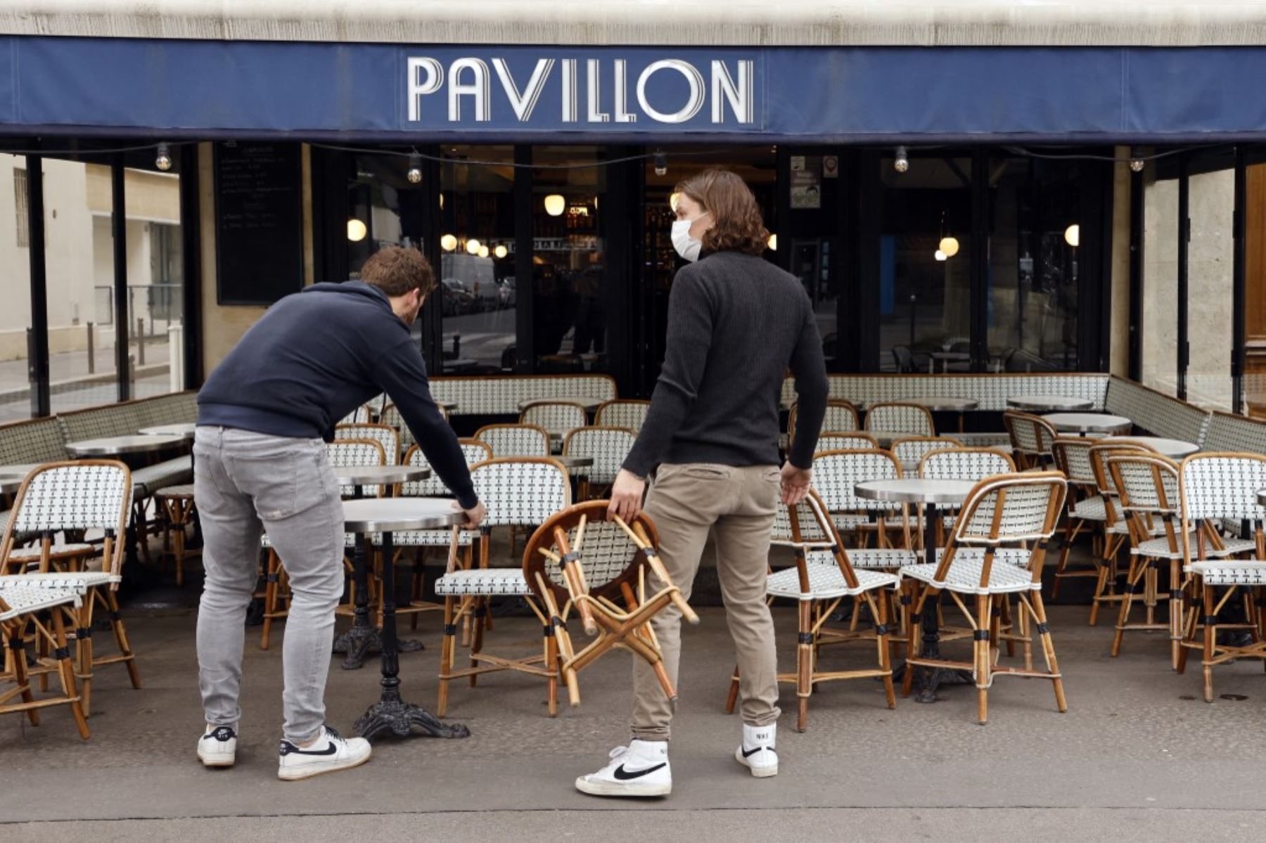Los empleados están trabajando para instalar la terraza de un café el 17 de mayo de 2021 en París, dos días antes de la reapertura de bares y restaurantes en Francia, el último paso hacia el fin del tercer cierre nacional de Covid-19 en Francia. Foto: AFP